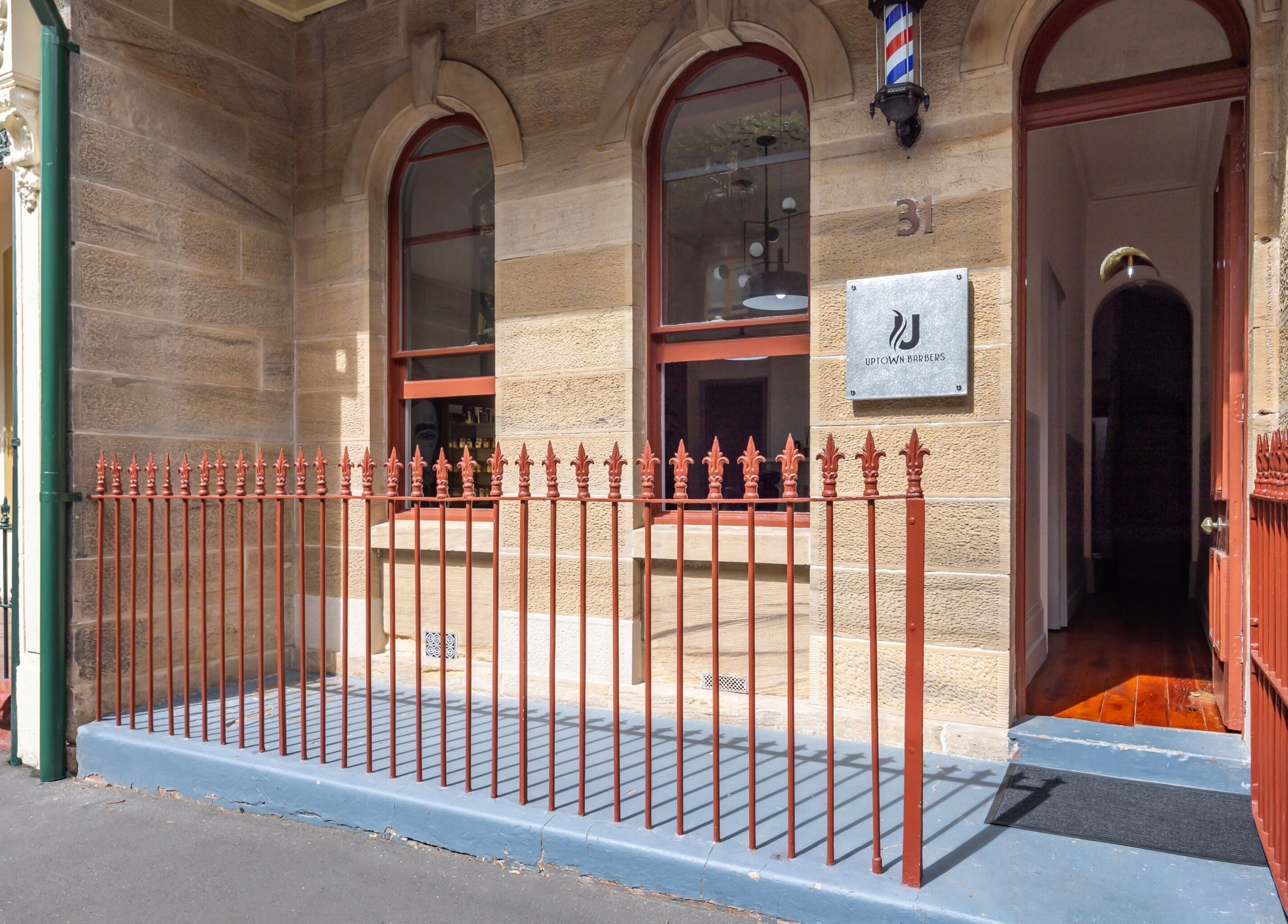 Uptown Barbers The Rocks entrance at The Rocks, New South Wales, AU, featuring a classic barber pole.