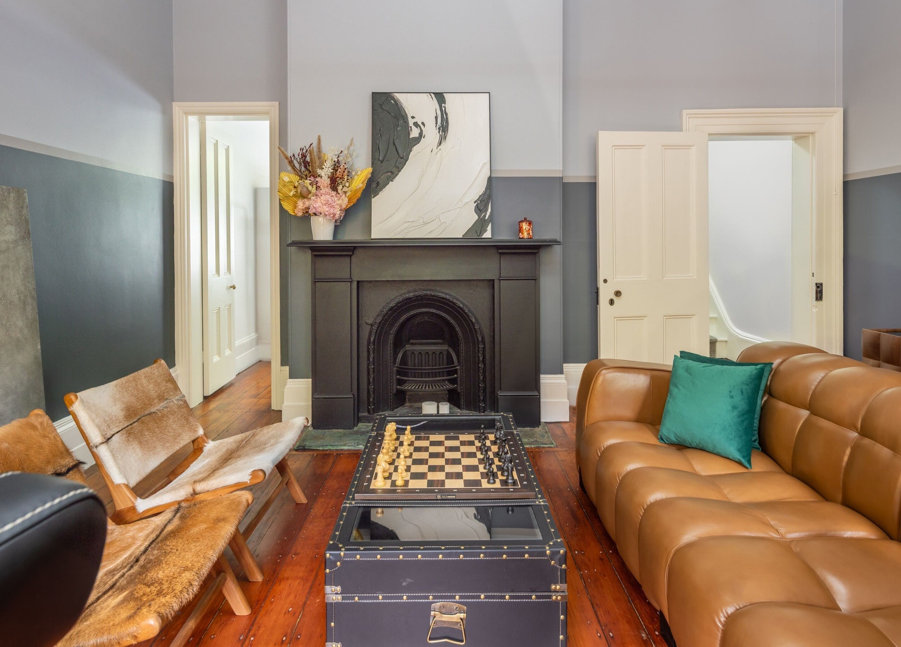 Chic lounge area at Uptown Barbers The Rocks, New South Wales, AU featuring leather sofa and fireplace.