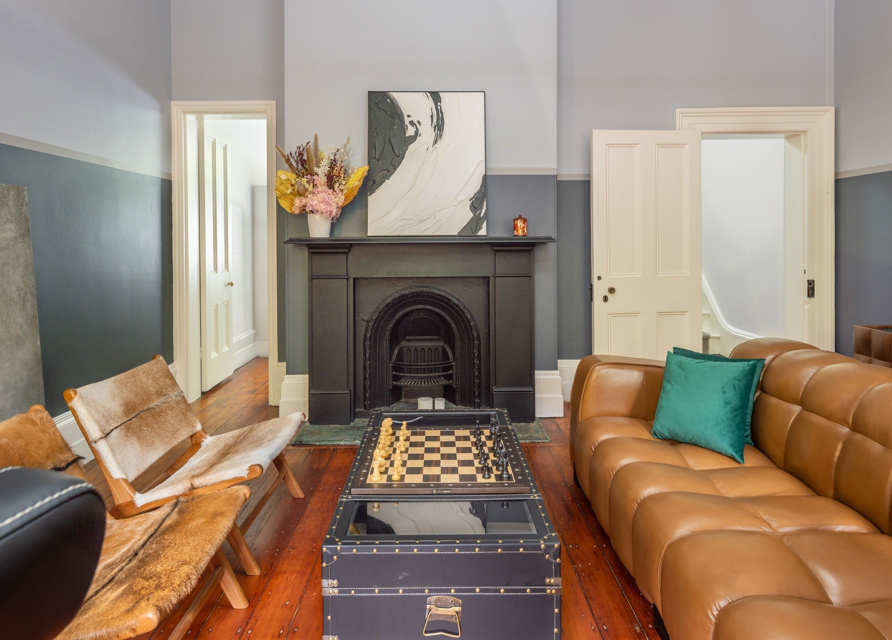 Chic lounge area at Uptown Barbers The Rocks, New South Wales, AU featuring leather sofa and fireplace.