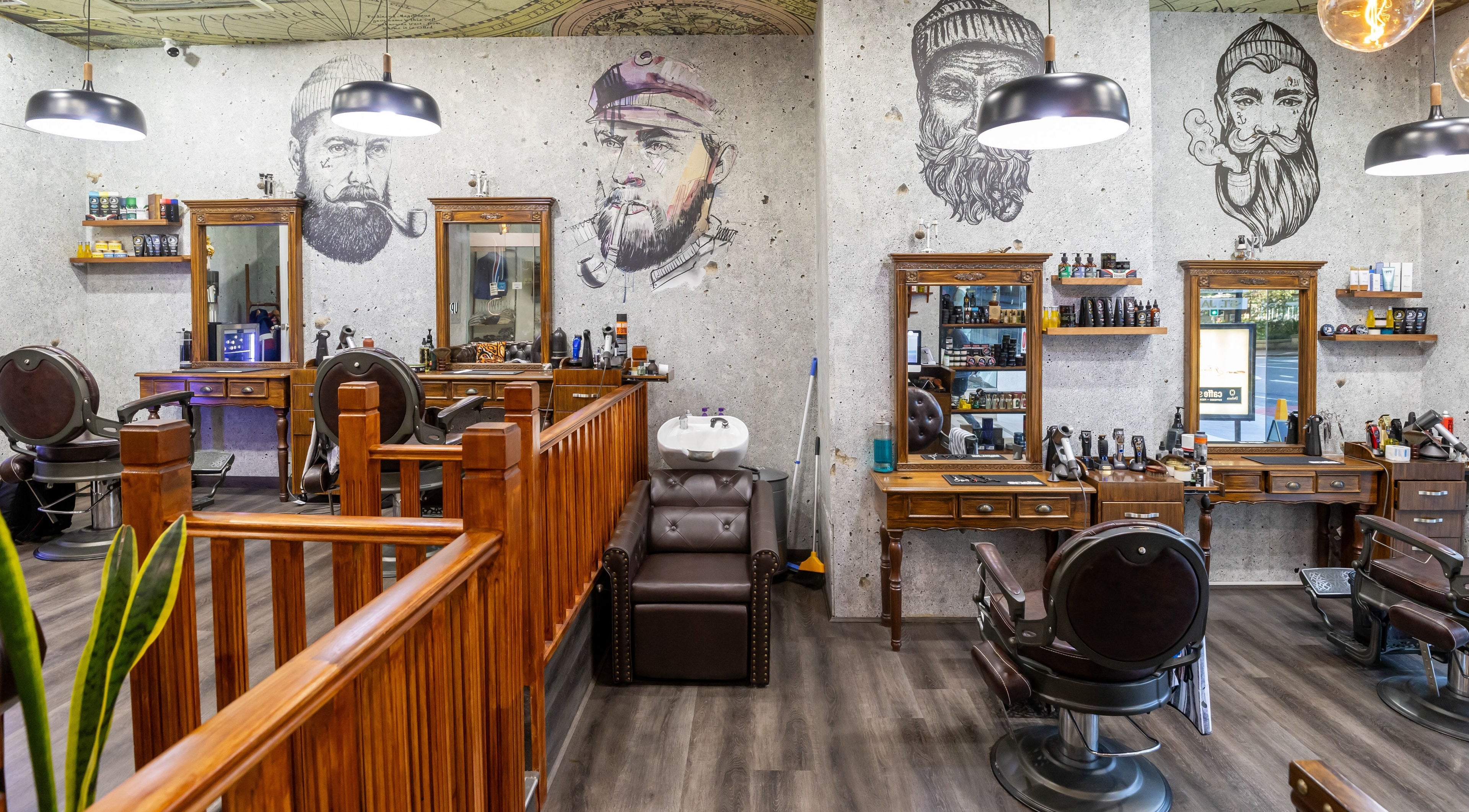 Interior of Uptown Barbers St James Arcade, Sydney, NSW, featuring stylish barber chairs and artistic wall murals.