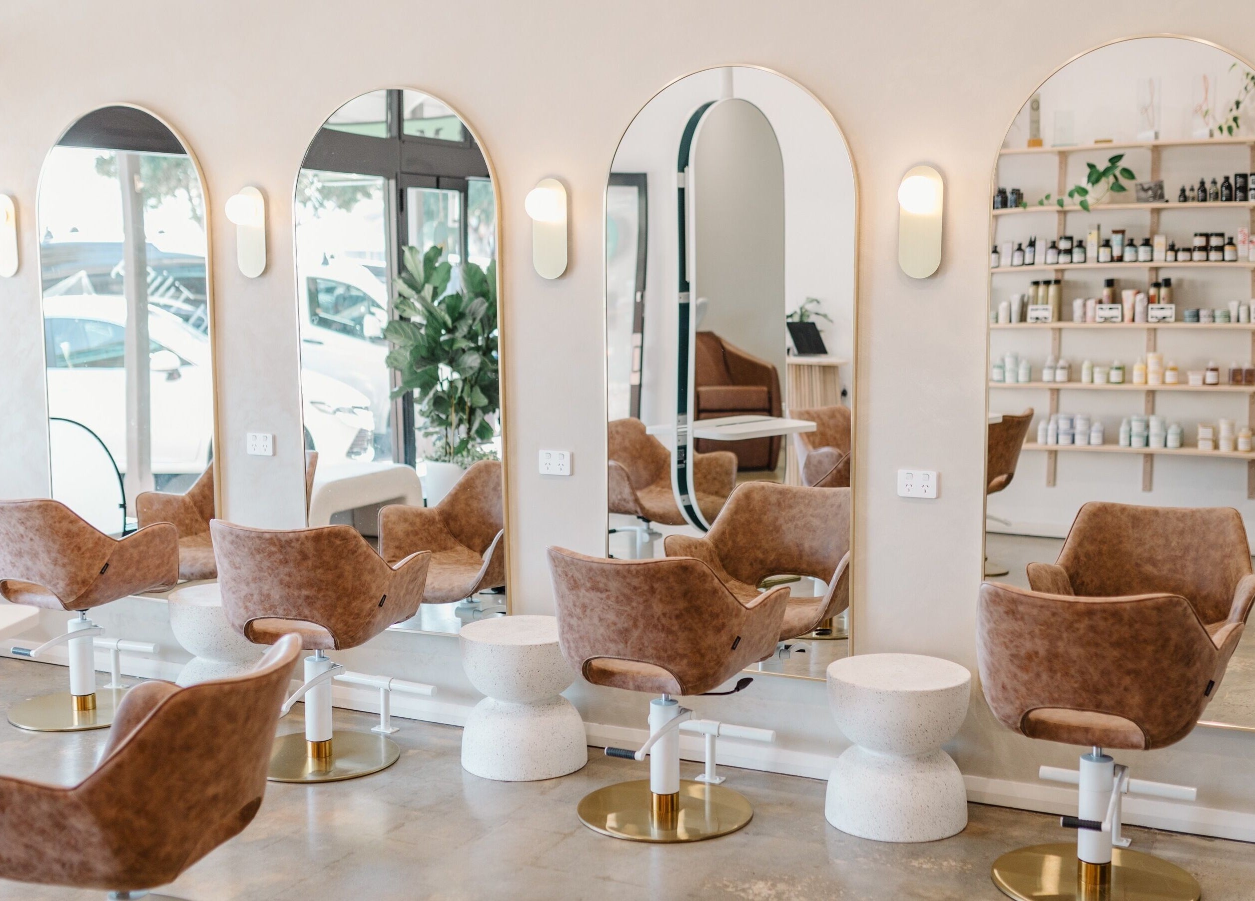 Modern hair salon interior at Mooi Studio, Glenelg, South Australia, AU featuring stylish chairs and large mirrors.