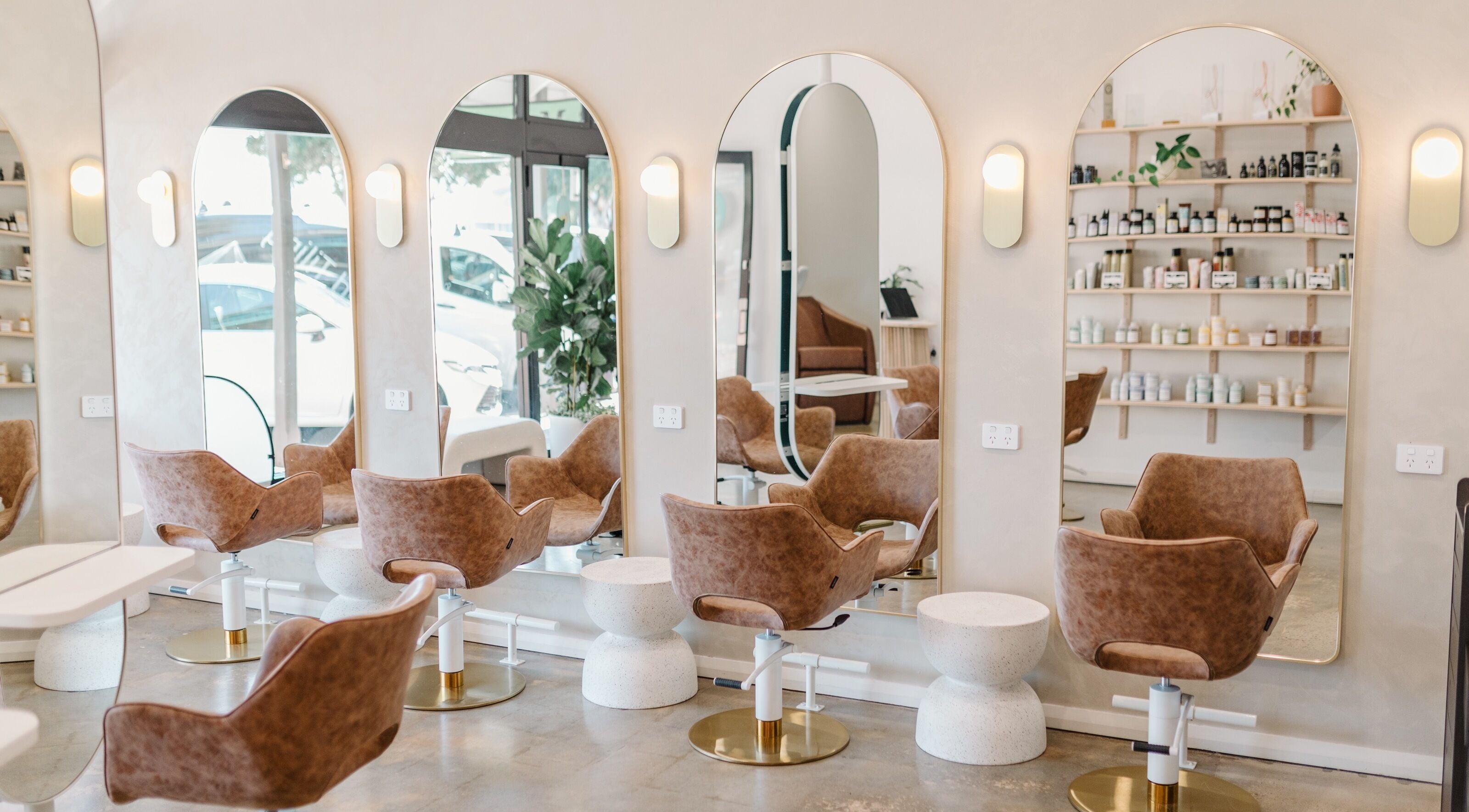 Modern hair salon interior at Mooi Studio, Glenelg, South Australia, AU featuring stylish chairs and large mirrors.