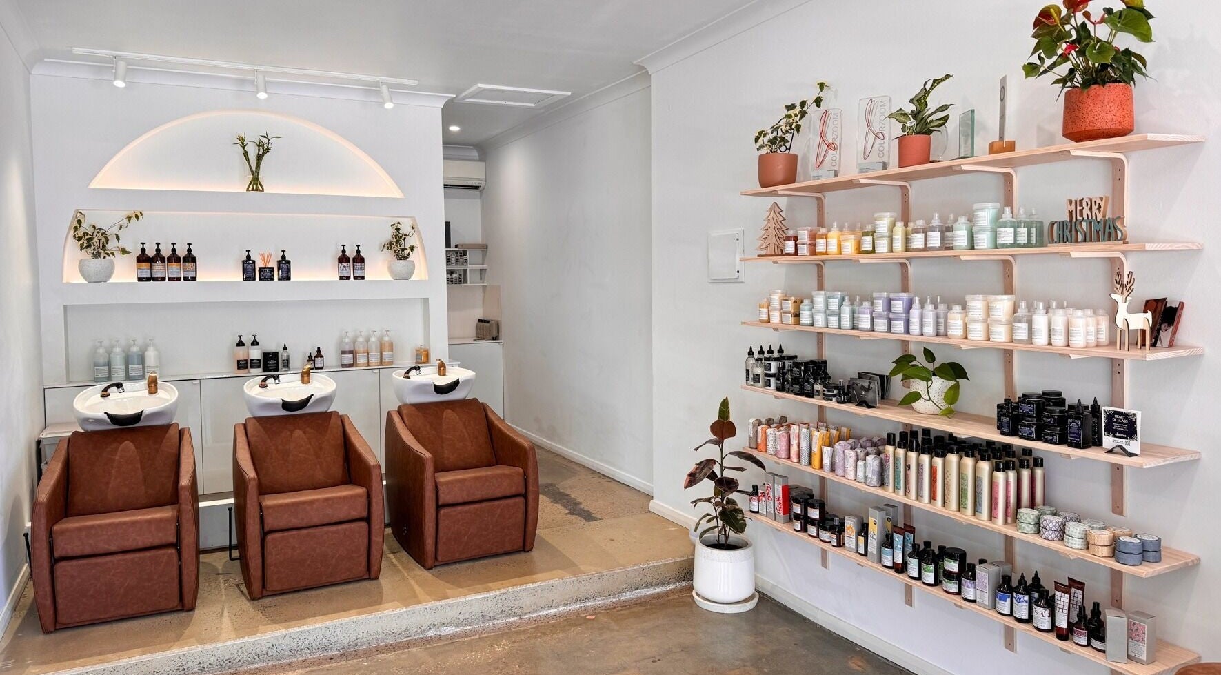 Elegant interior of Mooi Studio in Glenelg, South Australia, AU featuring salon chairs and product shelves.