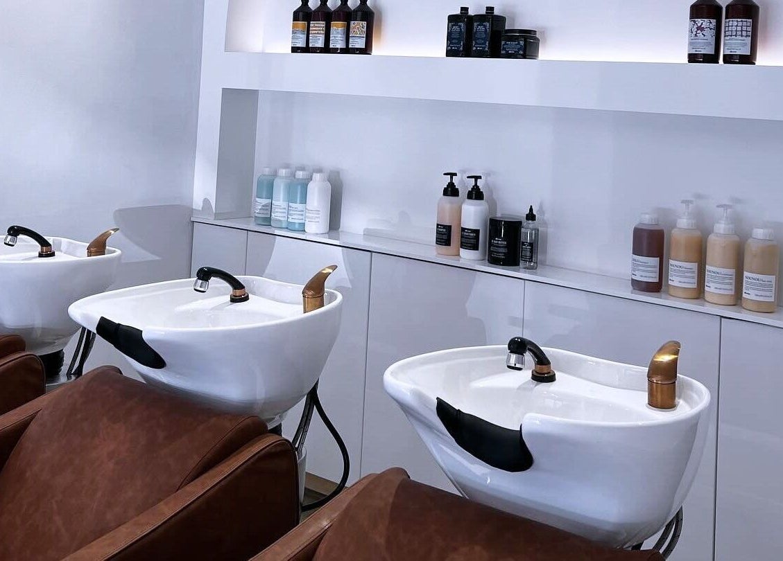 Sophisticated salon wash area at Mooi Studio, Glenelg, South Australia, AU, featuring stylish chairs and products.