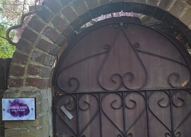 Intricate iron gate with a sign of FAB-U-LOIS Beauty and Aesthetics, Rustington, England, GB.