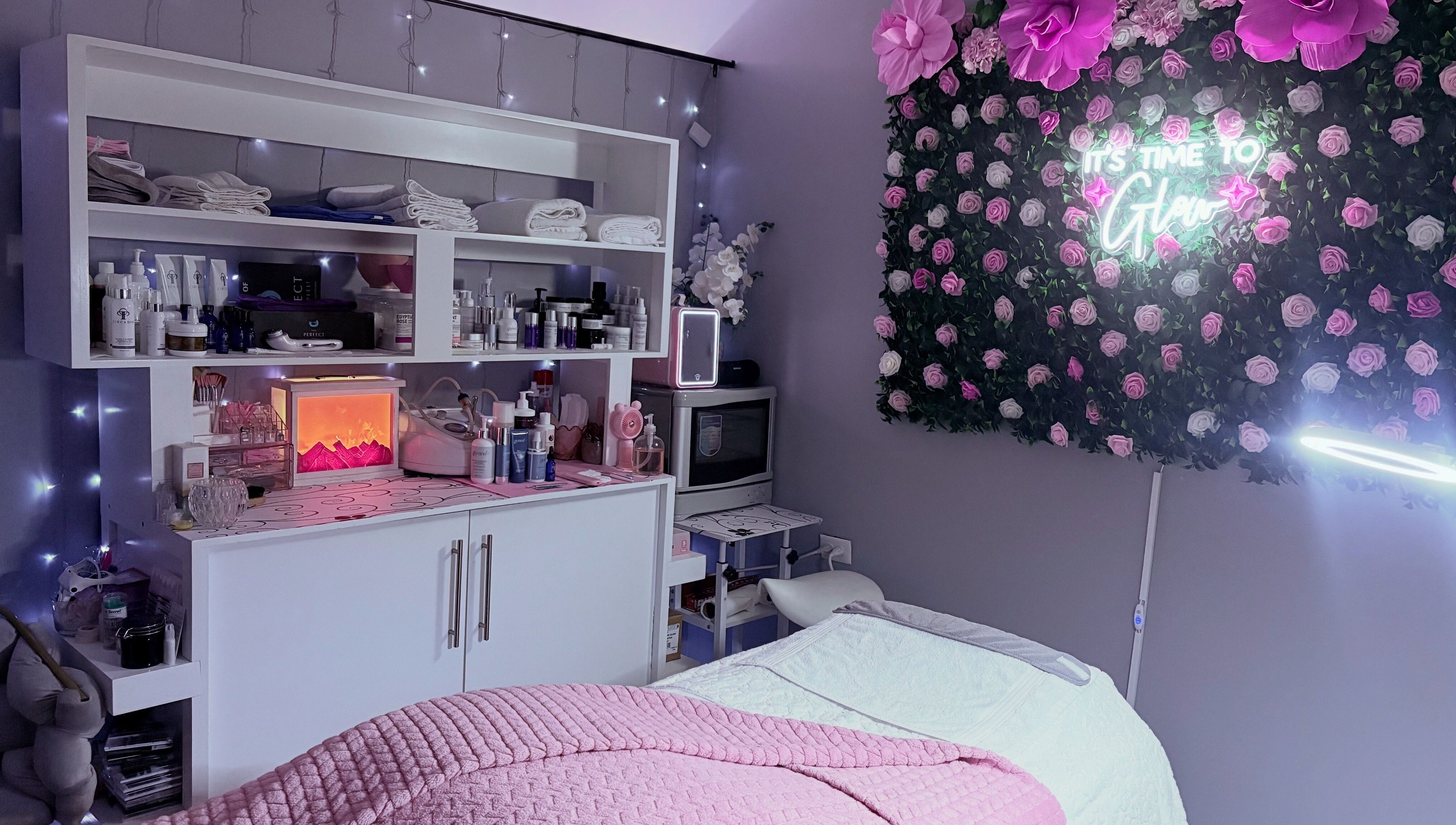Relaxing spa room at Skin Serenity Spa and Wax Studio, Tunapuna, adorned with pink flowers and beauty products.