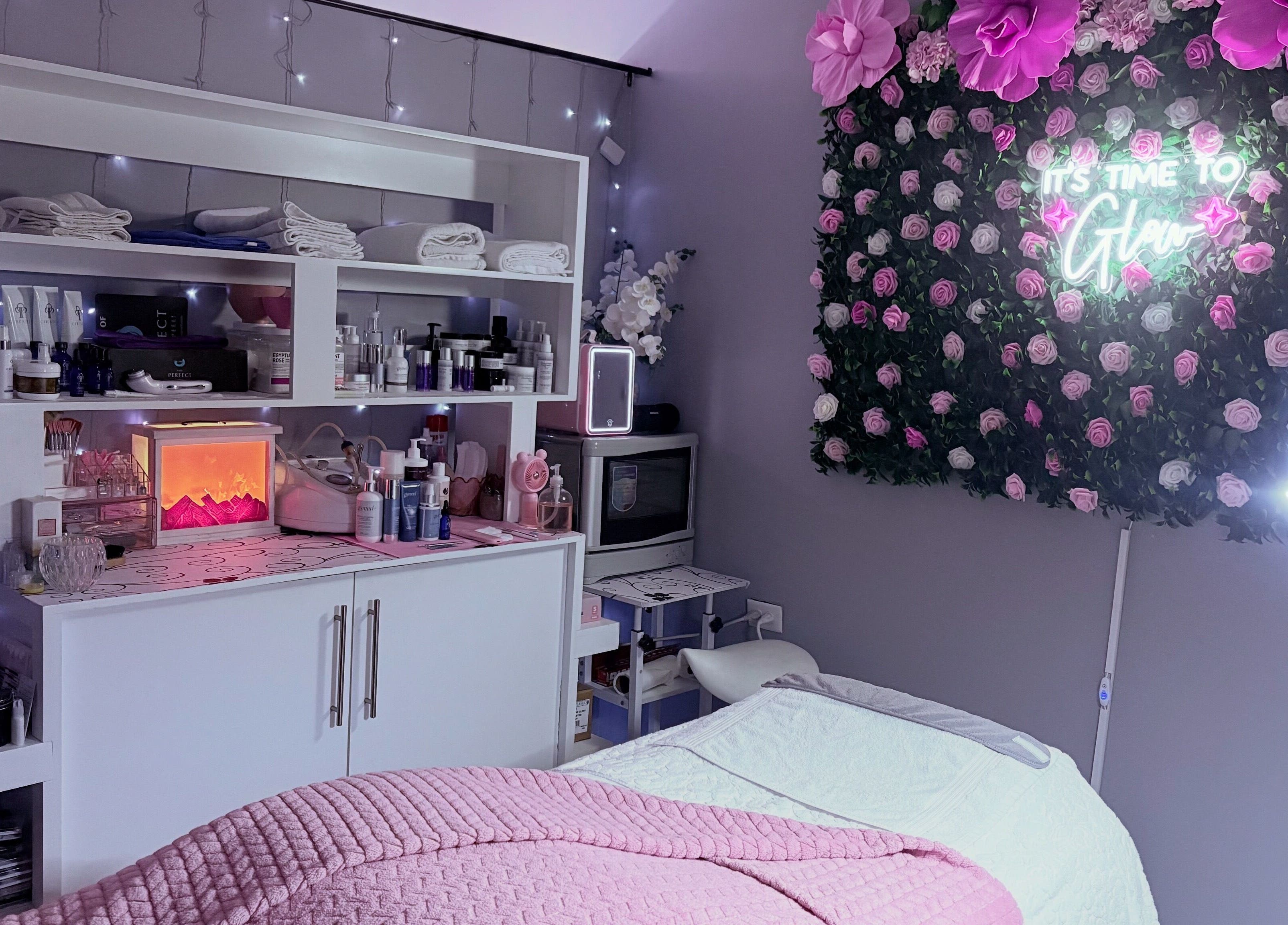 Relaxing spa room at Skin Serenity Spa and Wax Studio, Tunapuna, adorned with pink flowers and beauty products.