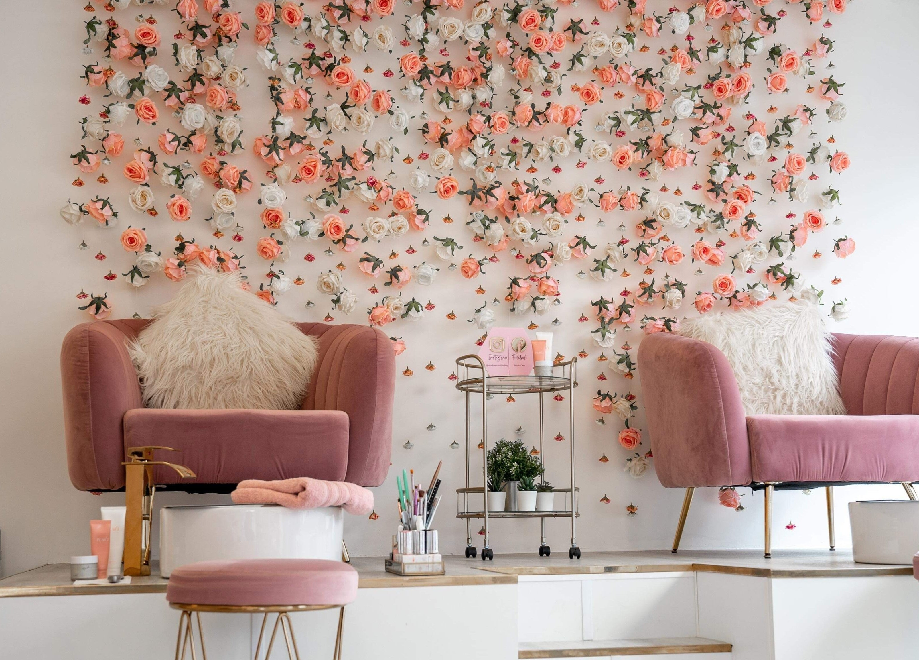 Chic salon chairs with floral wall at Studio One Nails and Beauty in New Milton, England, GB.