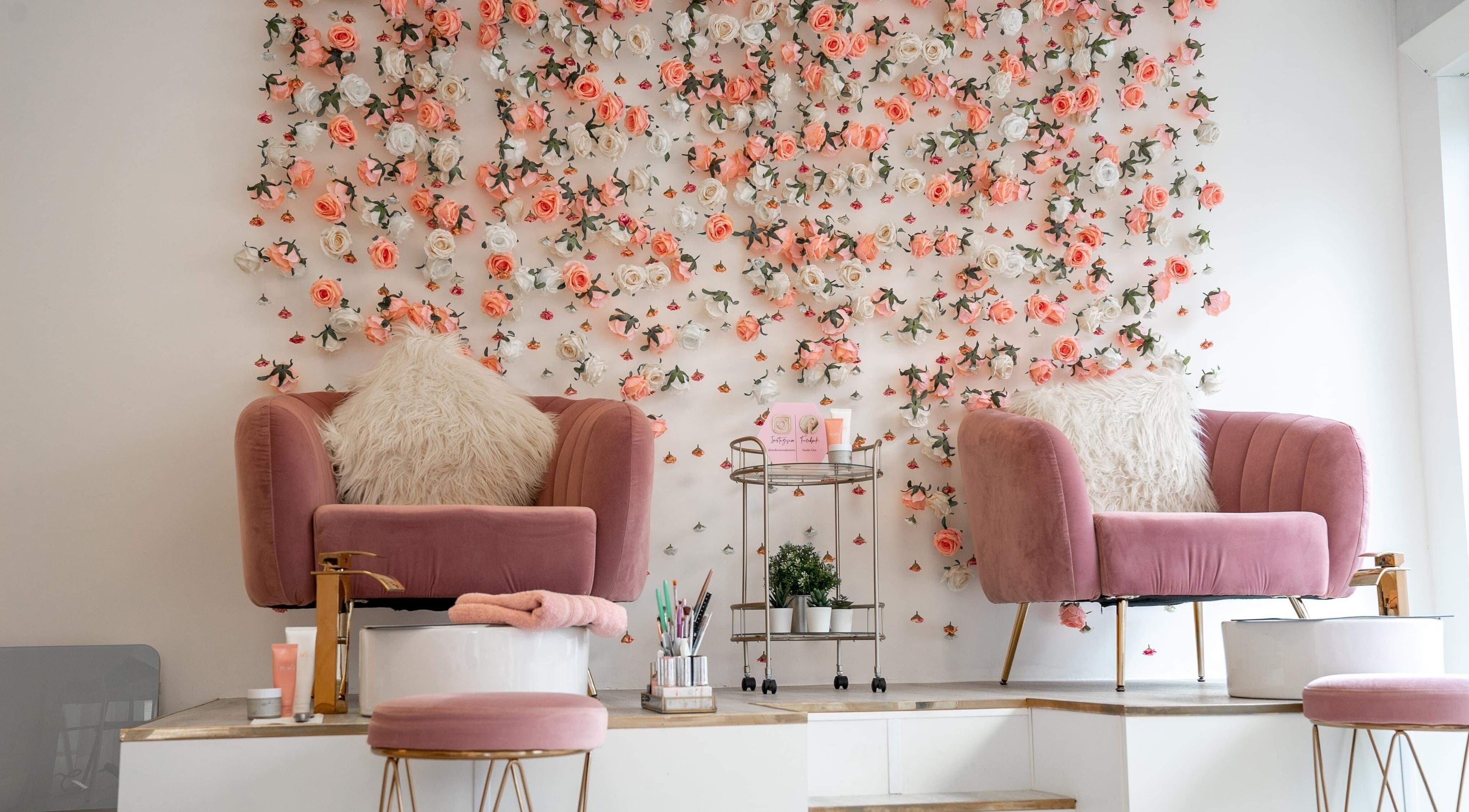 Chic salon chairs with floral wall at Studio One Nails and Beauty in New Milton, England, GB.