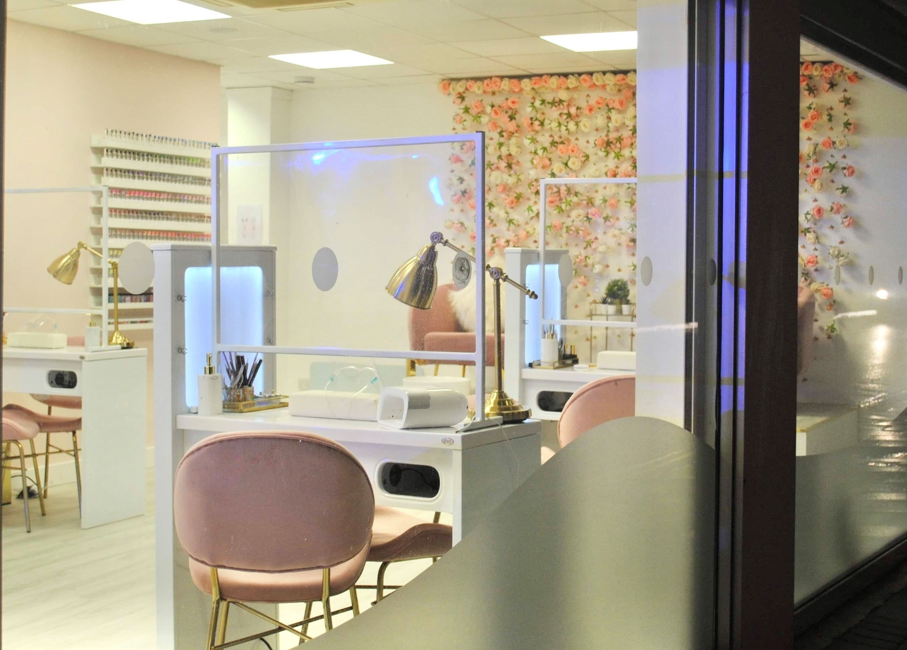 Elegant interior of Studio One Nails and Beauty in New Milton, England, GB with pink chairs and floral decor.