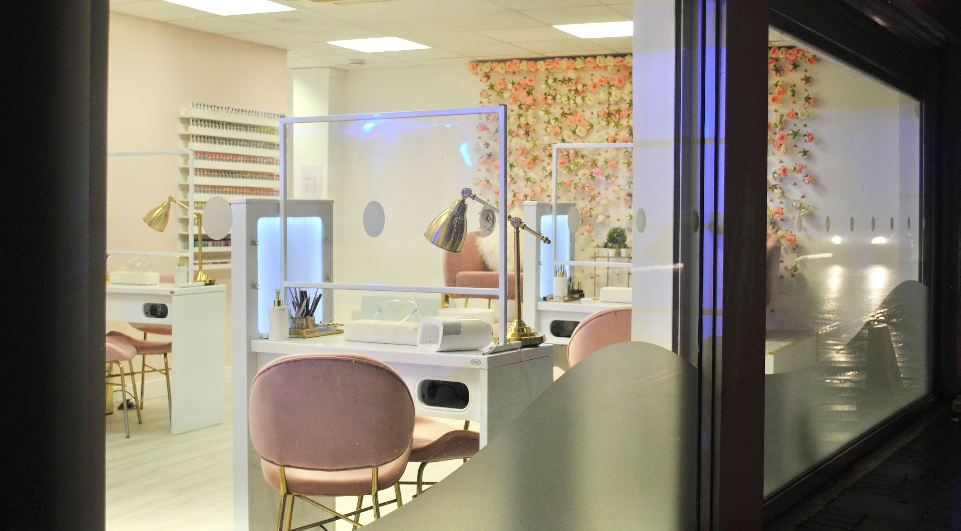 Elegant interior of Studio One Nails and Beauty in New Milton, England, GB with pink chairs and floral decor.