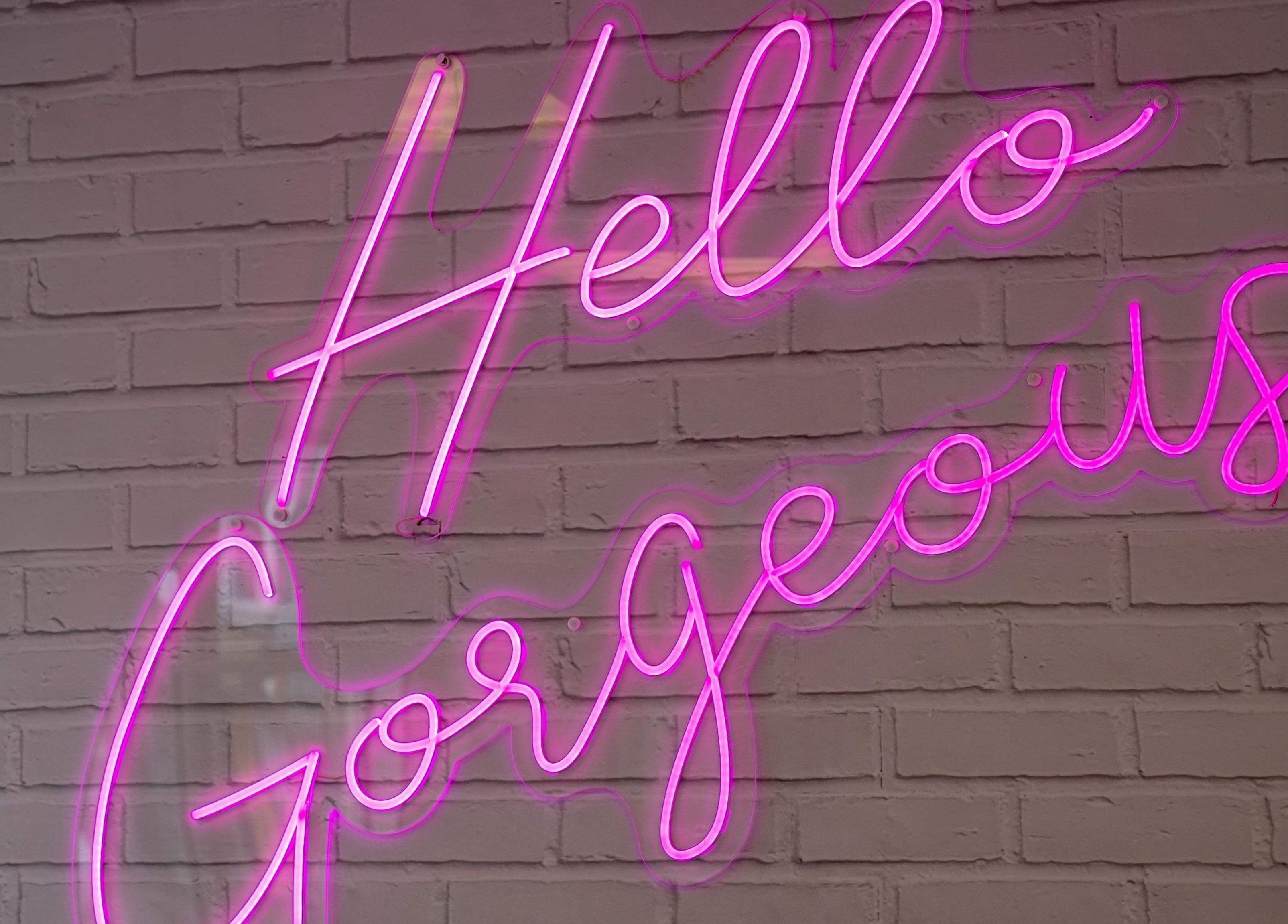 Pink neon sign reads 'Hello Gorgeous' at Studio One Nails and Beauty, New Milton, England, GB.