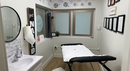 Cozy treatment room at Naked Truth, Welland, Ontario, CA, featuring a massage table and modern decor.