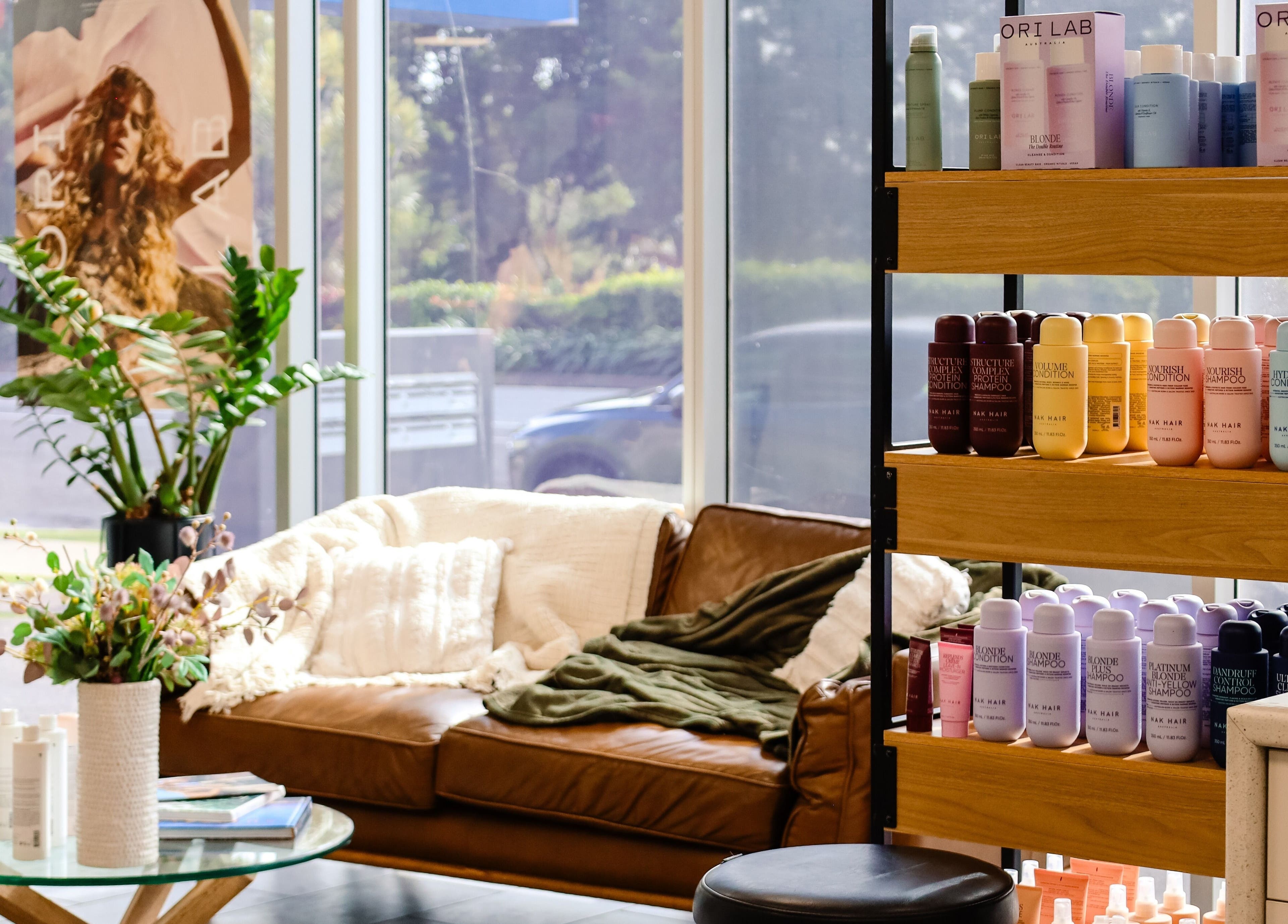Inviting lounge with hair products at Fusion Hair, Woree, Queensland, AU, showcasing a stylish interior.