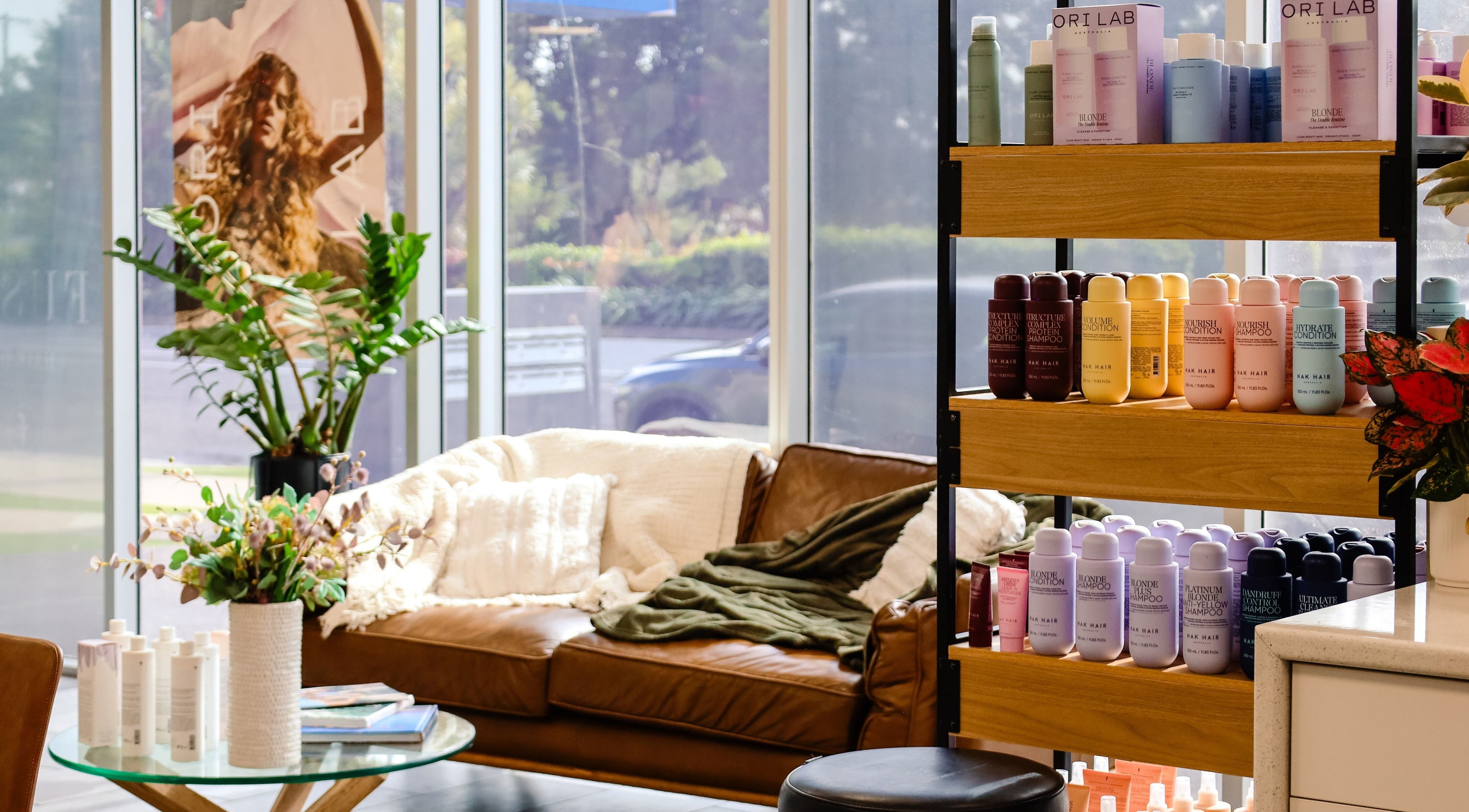 Inviting lounge with hair products at Fusion Hair, Woree, Queensland, AU, showcasing a stylish interior.