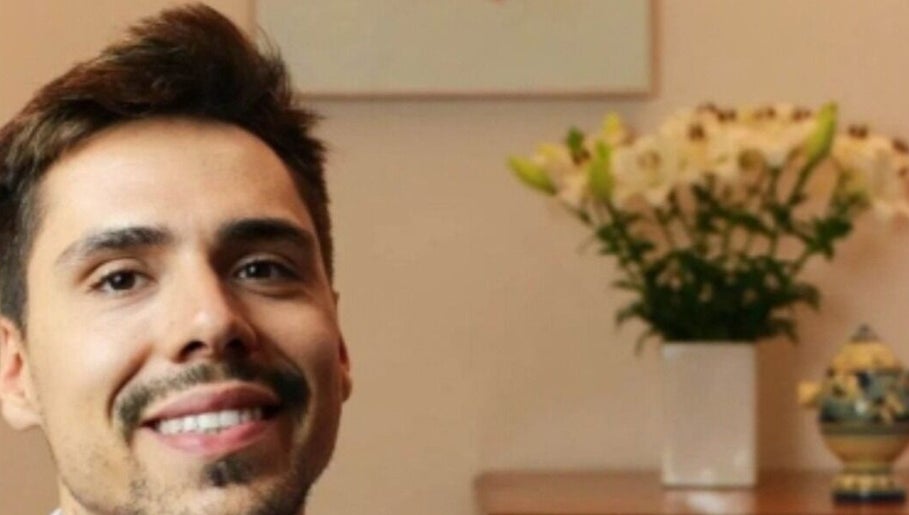 Smiling person at Massi Aldini, Paddington, New South Wales, AU, with floral decor in background.