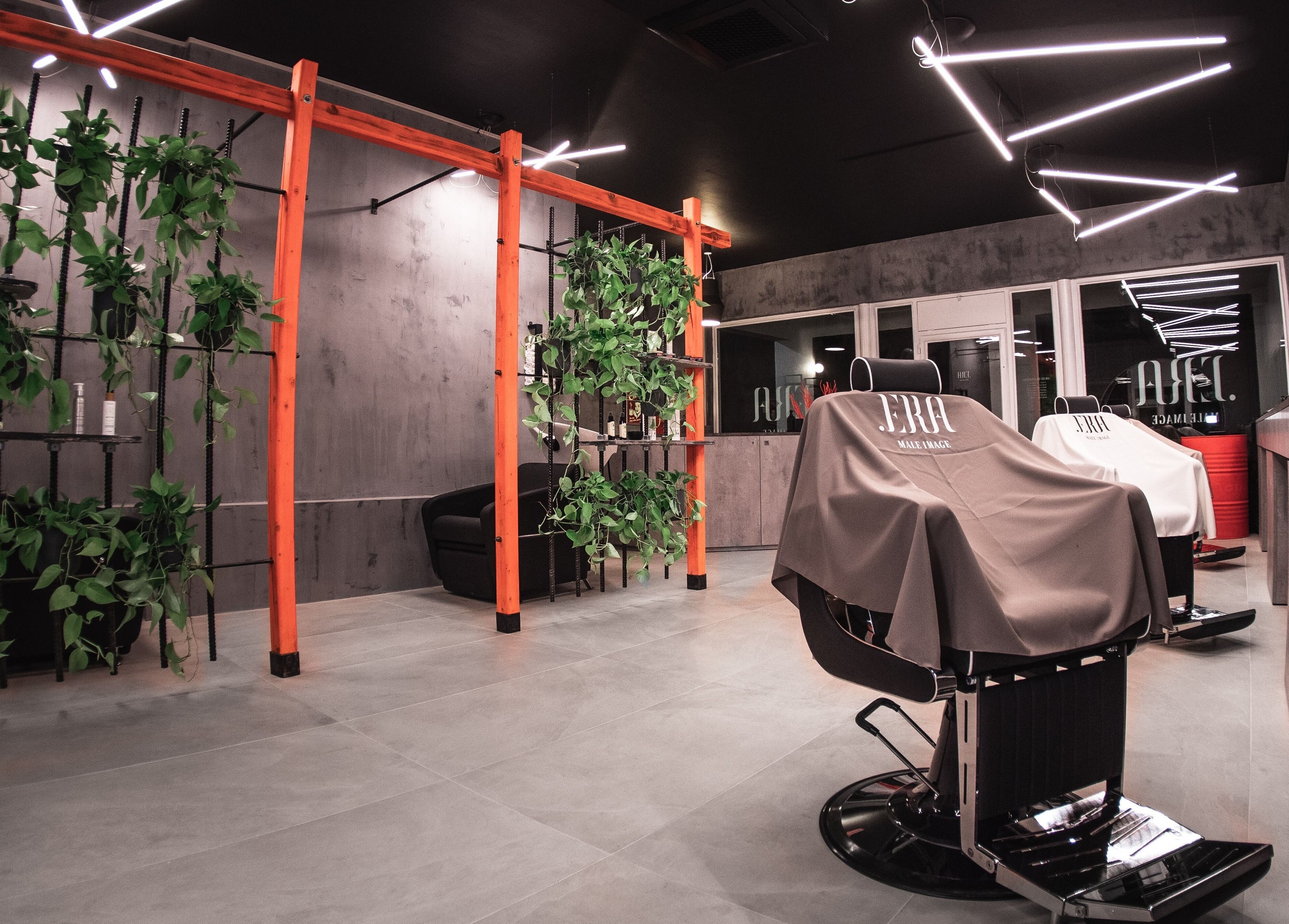 Interno moderno dello spazio .ERA Male Image a Parma, Emilia-romagna, IT, con eleganti poltrone e piante.