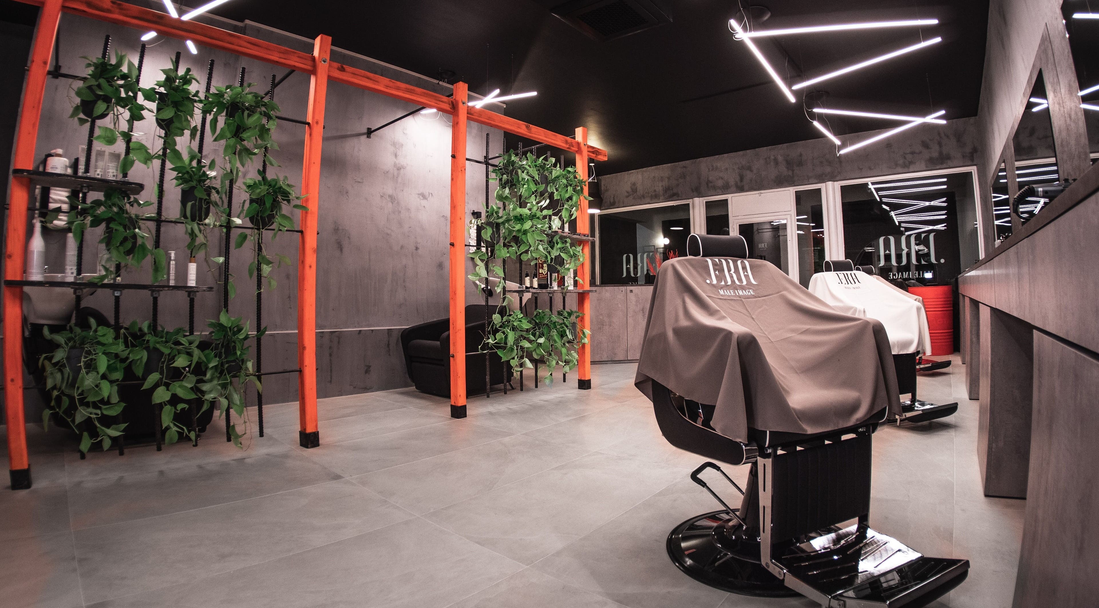 Interno moderno dello spazio .ERA Male Image a Parma, Emilia-romagna, IT, con eleganti poltrone e piante.