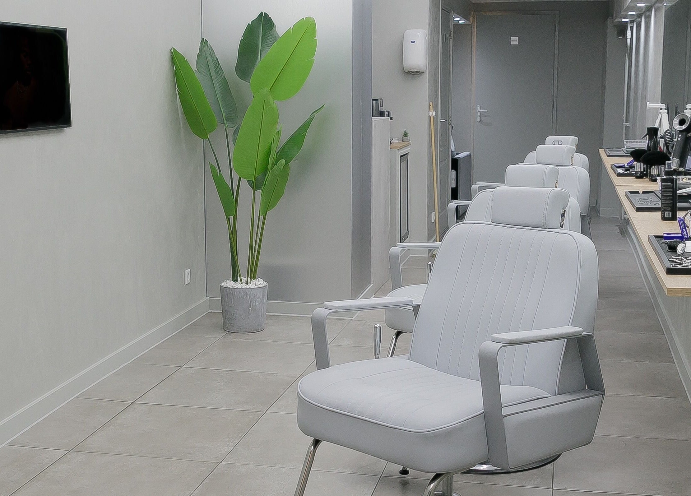 Stijlvolle inrichting van Essence Barbers (Oudenoord) in Utrecht, Utrecht, NL met moderne stoelen en groen decor.