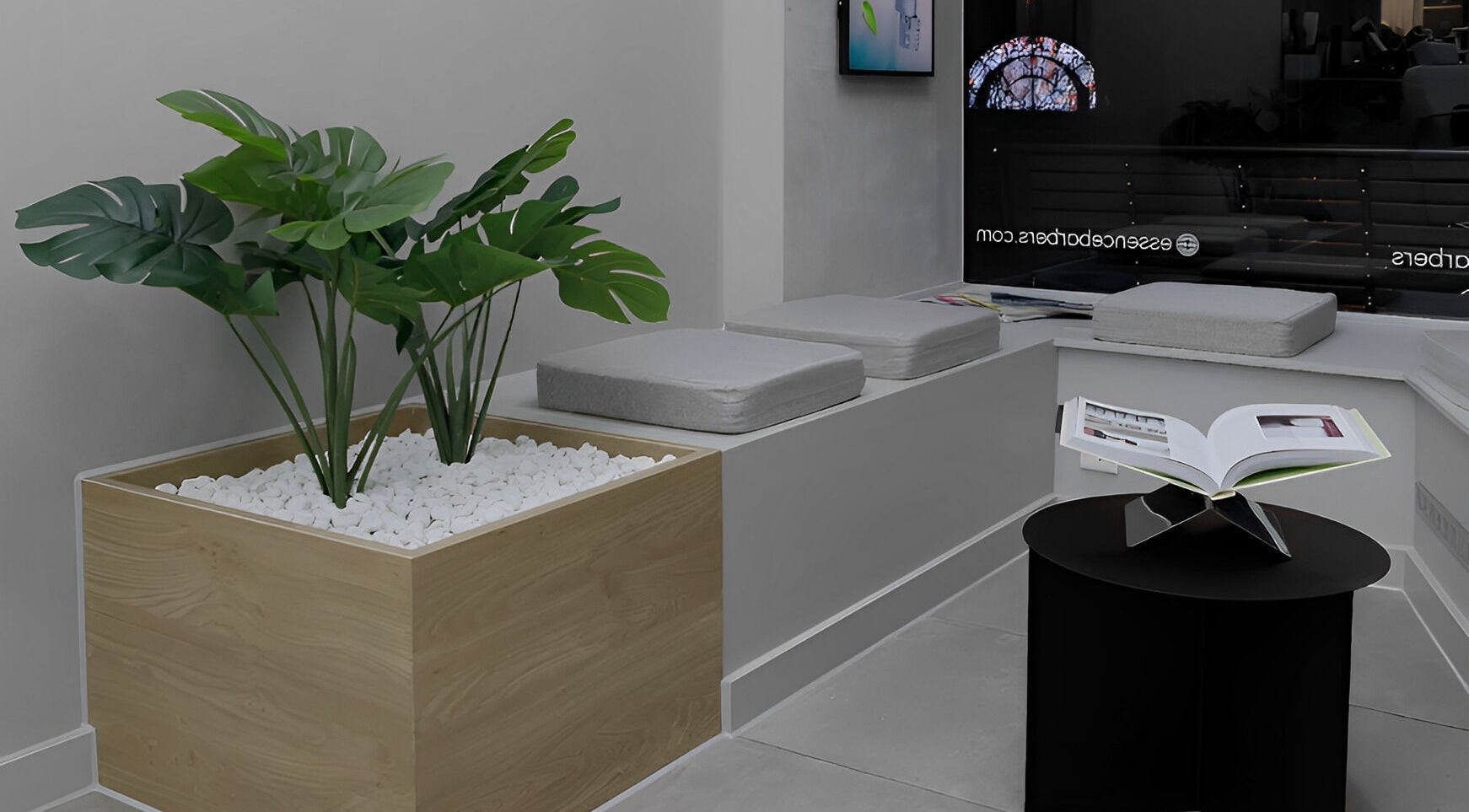 Stijlvolle wachtruimte bij Essence Barbers (Oudenoord), Utrecht, Utrecht, NL met plant en modern tafeltje.