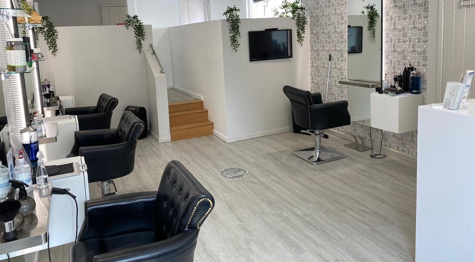 Chic interior of Luca James Hair and Beauty in Sawston, England featuring stylish black chairs and modern decor.