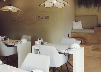 Elegant interior of Kri8tive Nails salon in Pretoria, Gauteng, ZA with manicure stations and cozy seating.