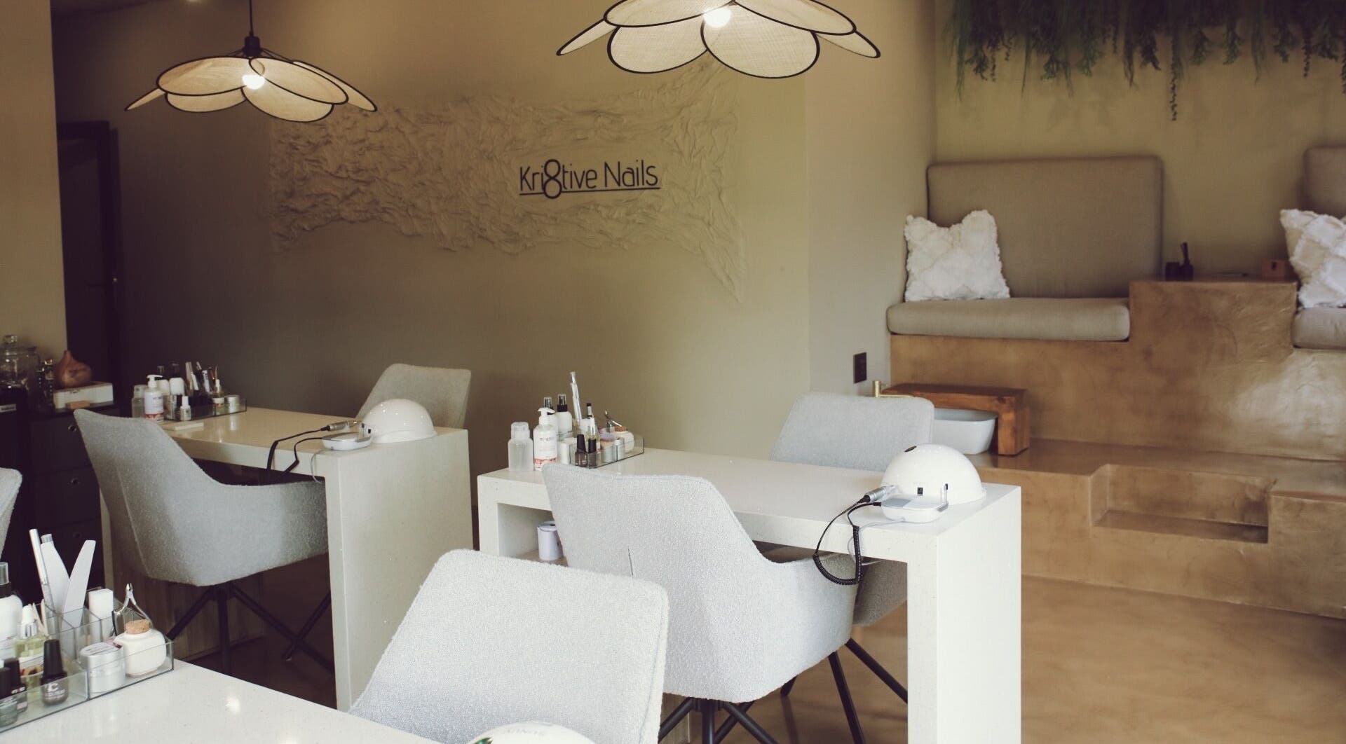 Elegant interior of Kri8tive Nails salon in Pretoria, Gauteng, ZA with manicure stations and cozy seating.