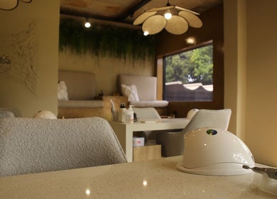 Chic interior of Kri8tive Nails in Pretoria, Gauteng, ZA showcasing modern nail stations and cozy seating.