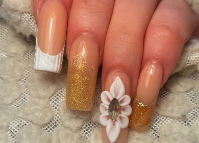 Elegant nail art with gold glitter and floral design at Holly’s Beauty, Bridgwater, England, GB.