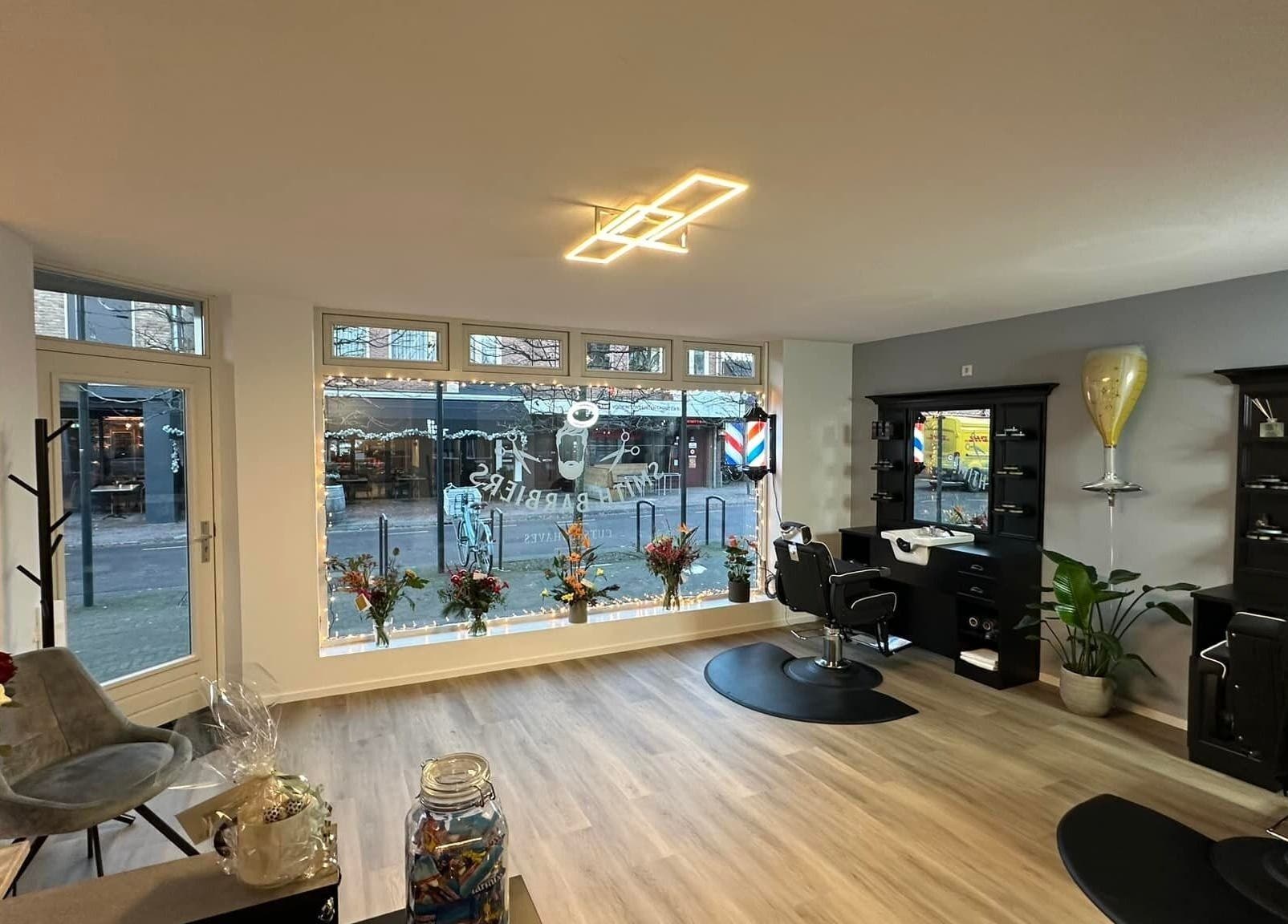 Smith Barbiers interieur met moderne inrichting in Woudenberg, Utrecht, NL. Stijlvolle kapsalon met bloemen en verlichting.