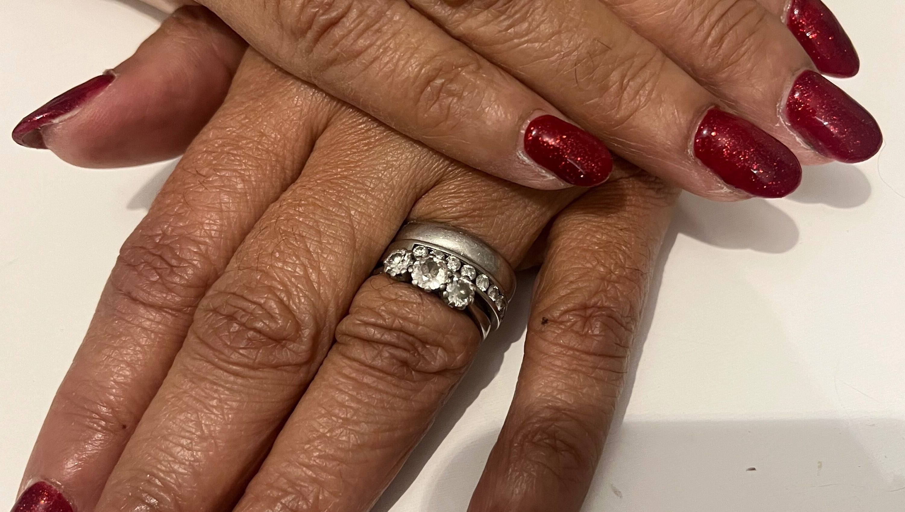 Red manicured nails with a diamond ring at Pretty Uneek at Home, Worthing, England, GB, showcasing elegance.