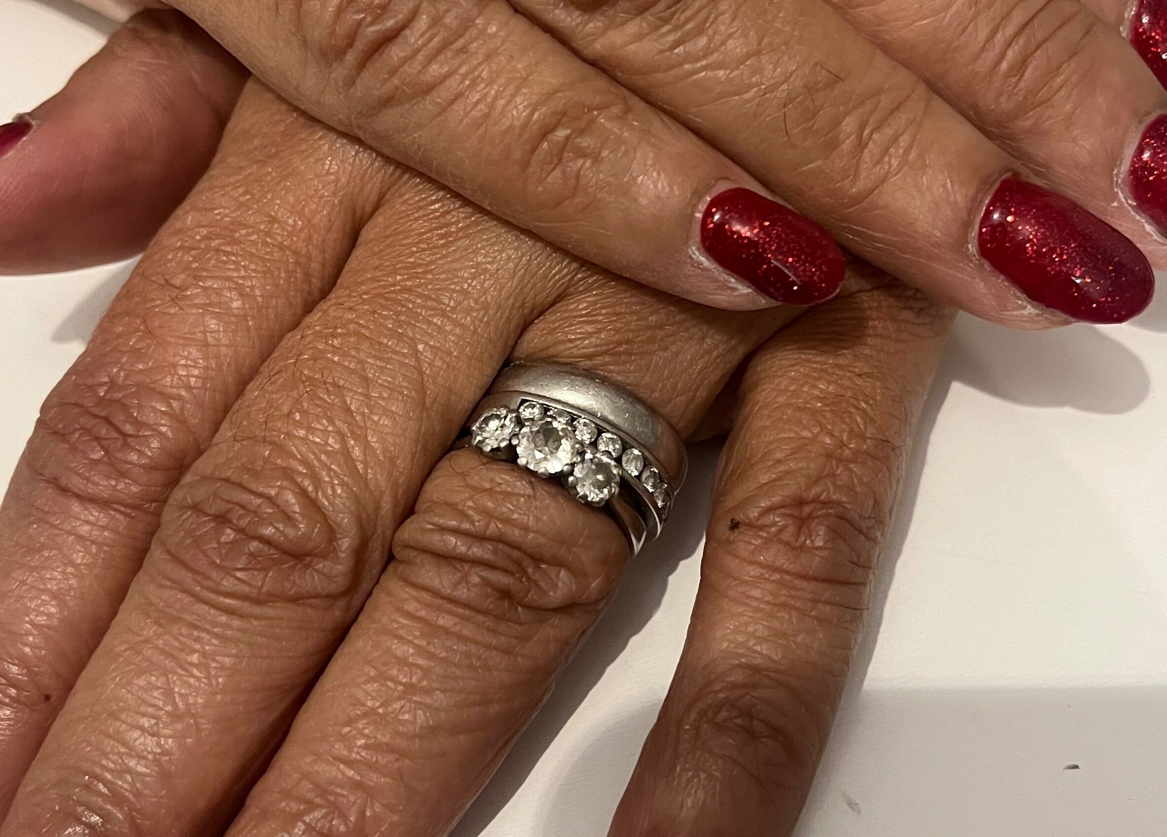 Red manicured nails with a diamond ring at Pretty Uneek at Home, Worthing, England, GB, showcasing elegance.