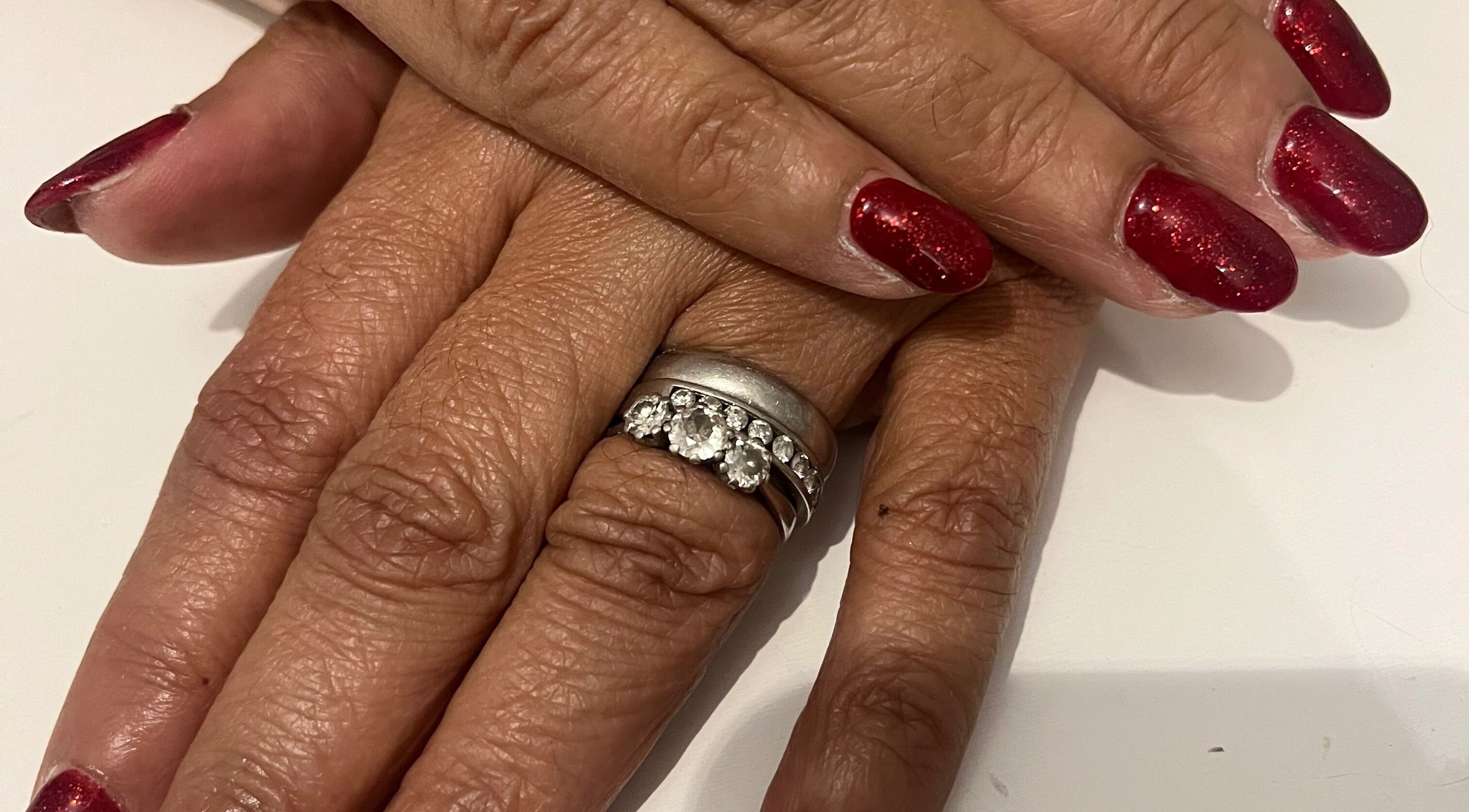 Red manicured nails with a diamond ring at Pretty Uneek at Home, Worthing, England, GB, showcasing elegance.