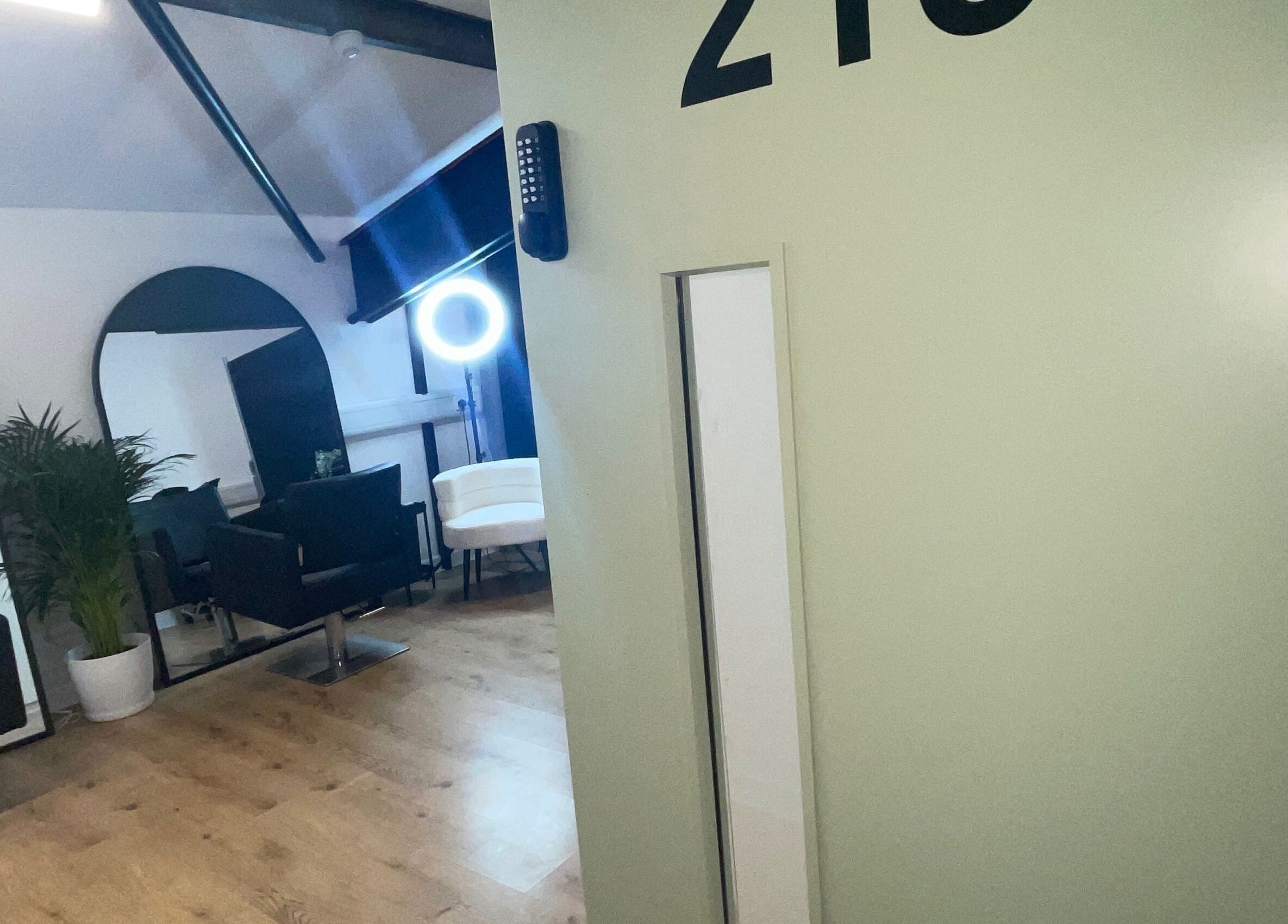 Interior of Jack Anthony Aesthetics, London, showcasing chic salon chairs and mirrors in a modern setting.