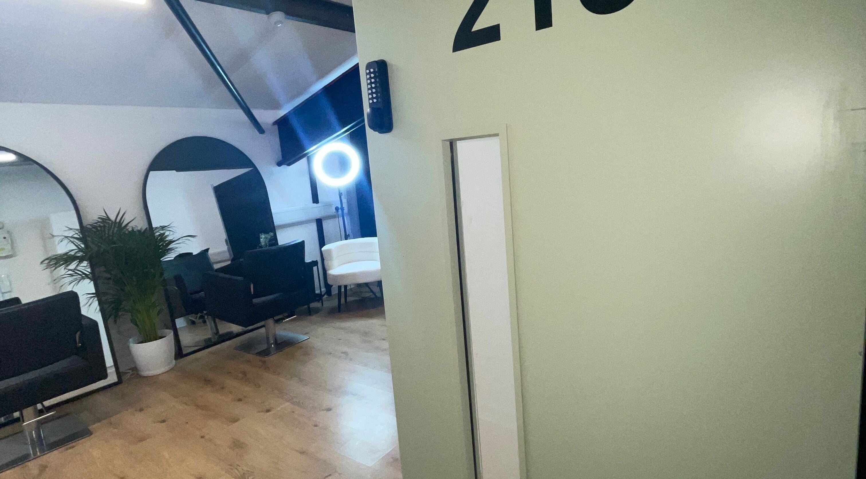 Interior of Jack Anthony Aesthetics, London, showcasing chic salon chairs and mirrors in a modern setting.