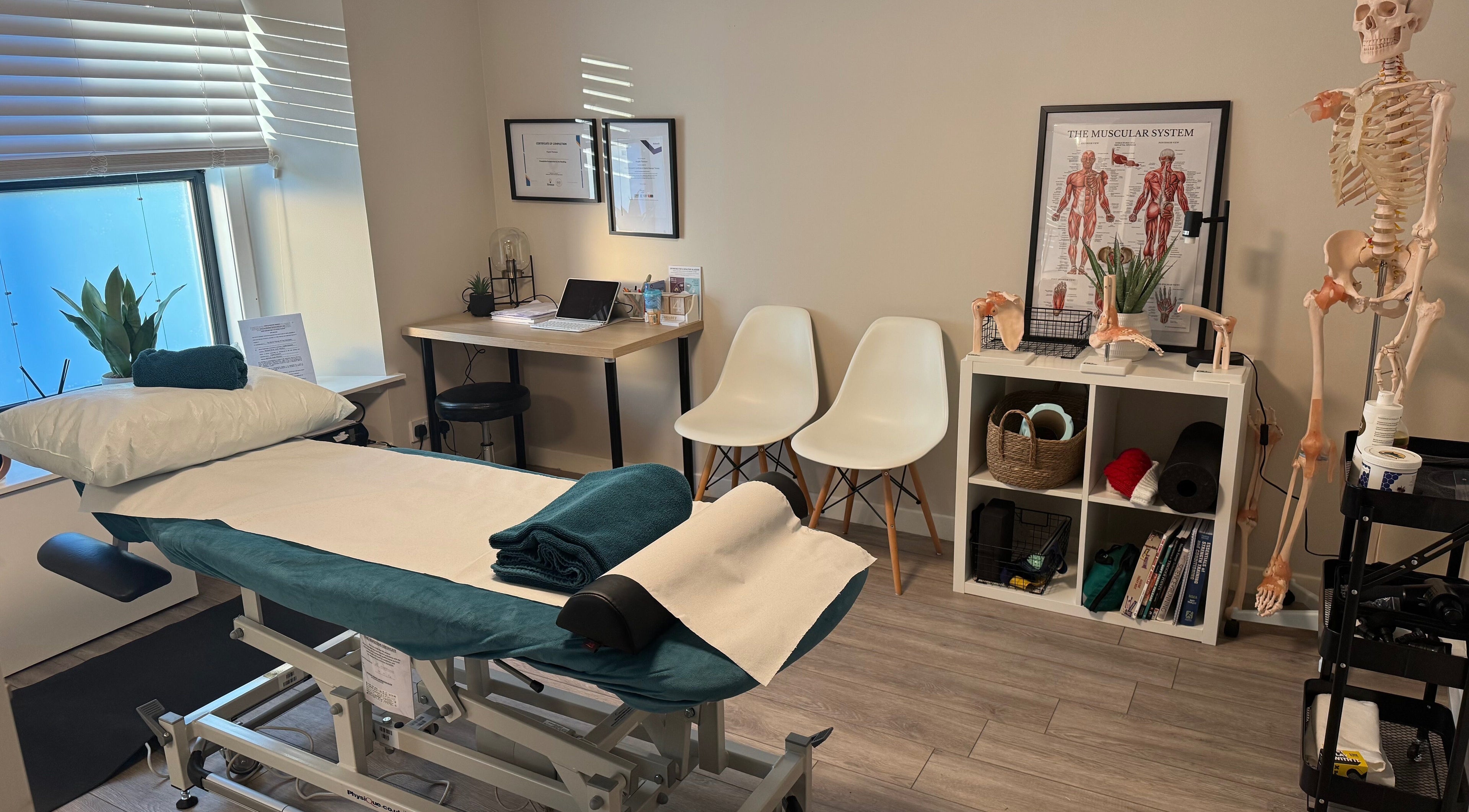 Tay Sports Therapy treatment room in Perth, Scotland, GB, featuring a massage table and anatomical models.