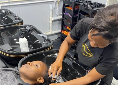 A stylist washes a client's hair at Hava's Beauty Bar, Port of Spain, enhancing relaxation and care.