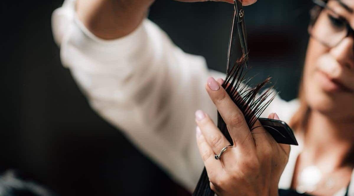 Expert stylist at Headcases Hair Salon in Ashbourne, IE skillfully cutting hair with precision scissors.