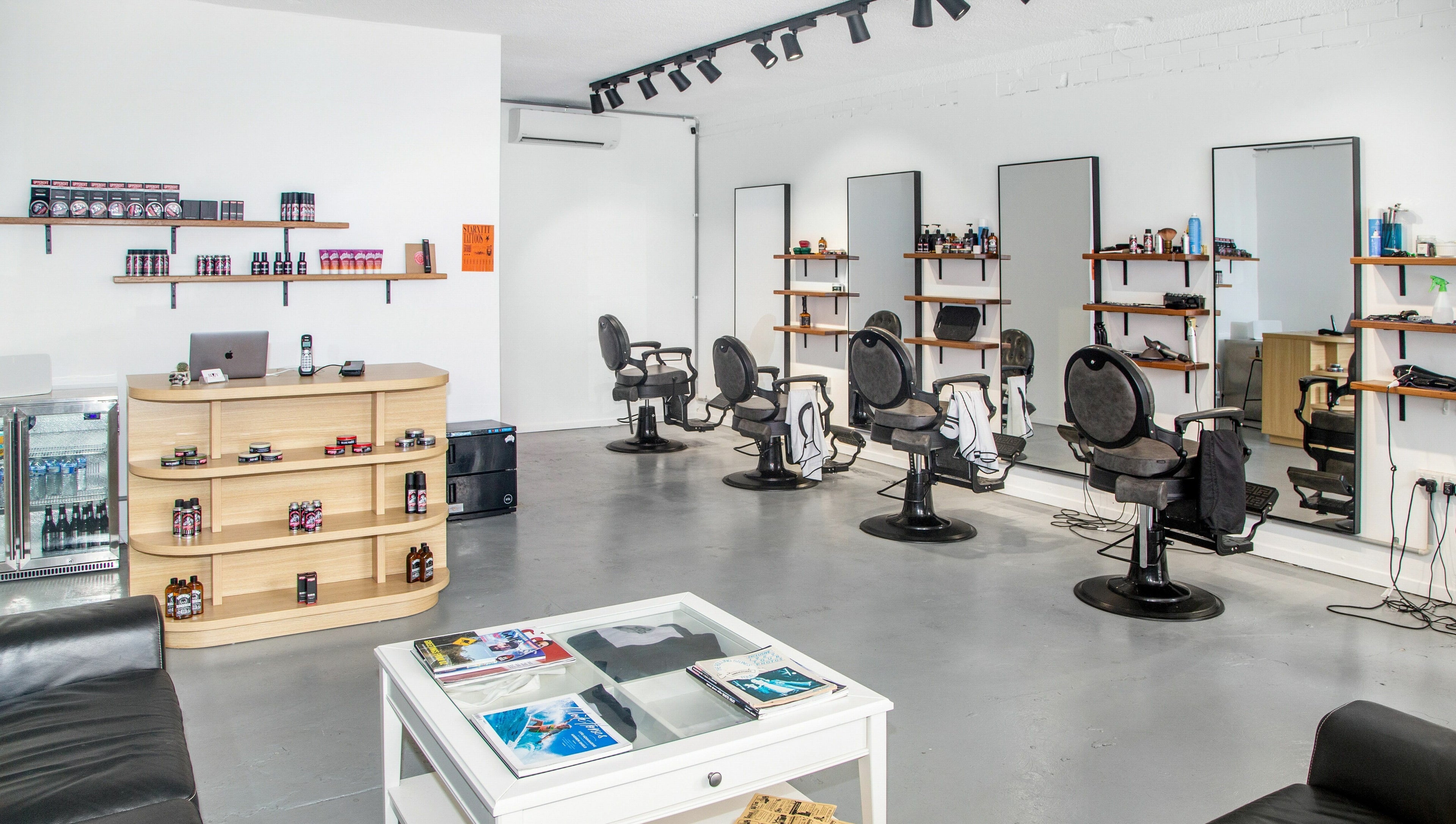 Interior of Boy Barbershop - Coolangatta, QLD, AU, featuring stylish chairs and grooming products.