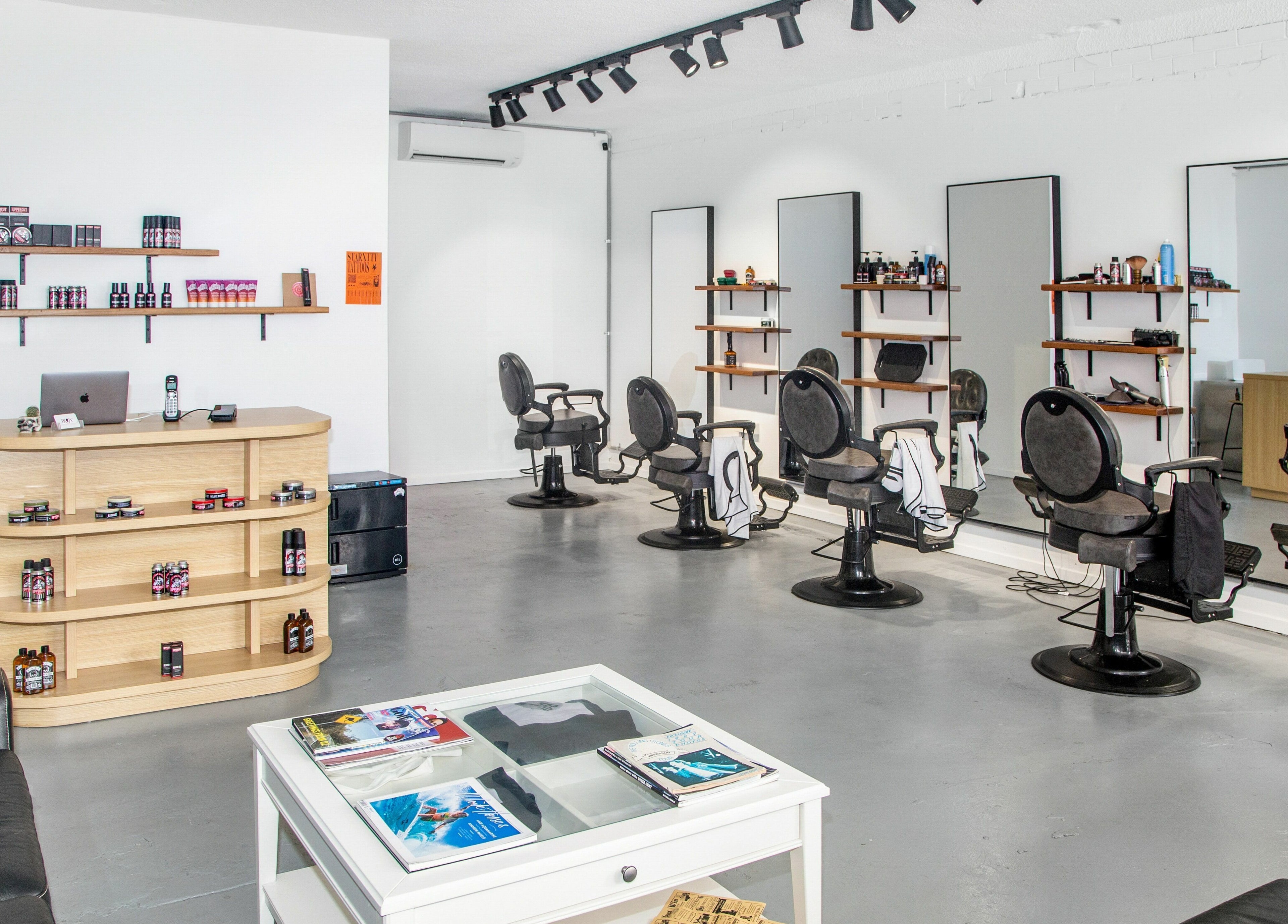 Interior of Boy Barbershop - Coolangatta, QLD, AU, featuring stylish chairs and grooming products.