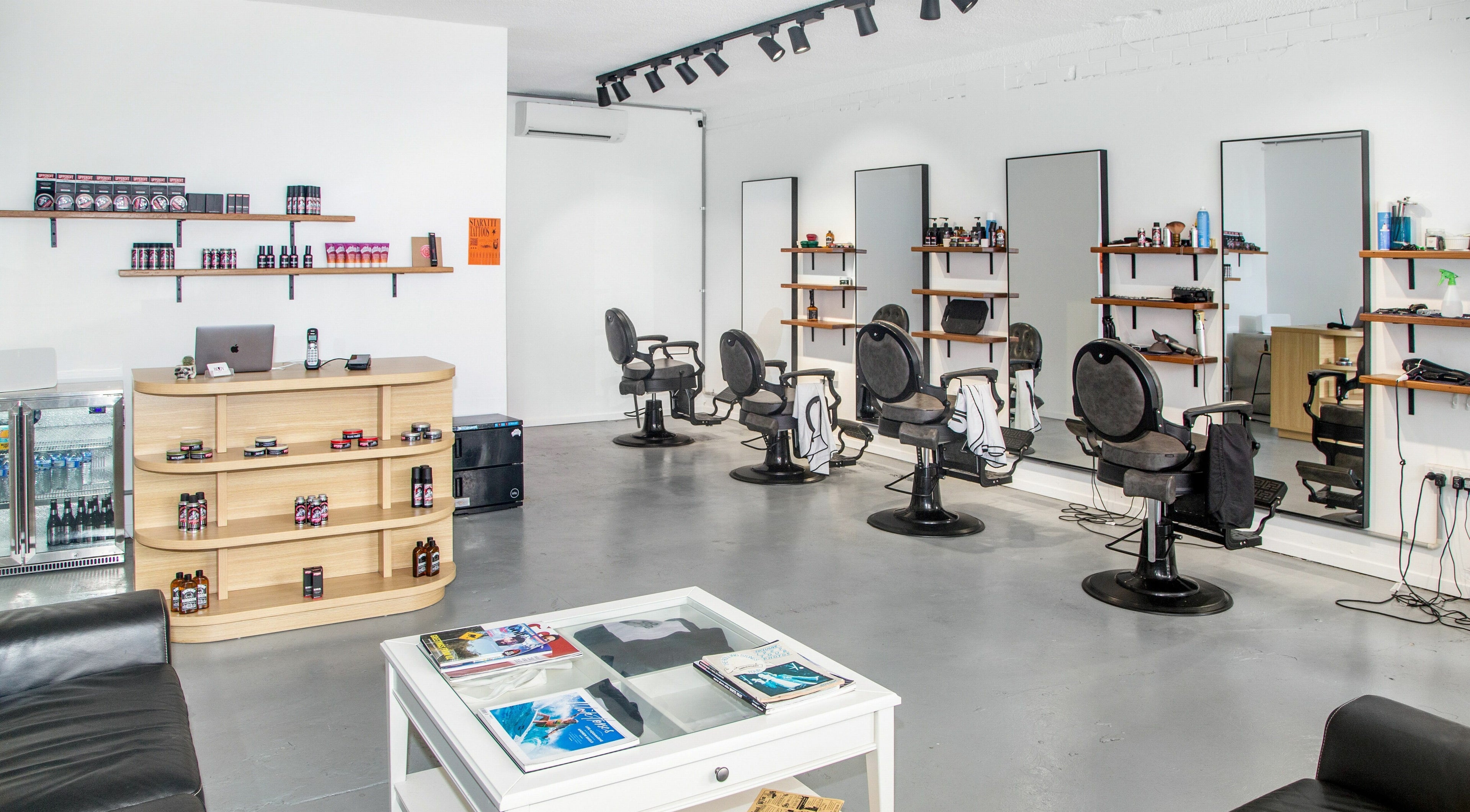 Interior of Boy Barbershop - Coolangatta, QLD, AU, featuring stylish chairs and grooming products.