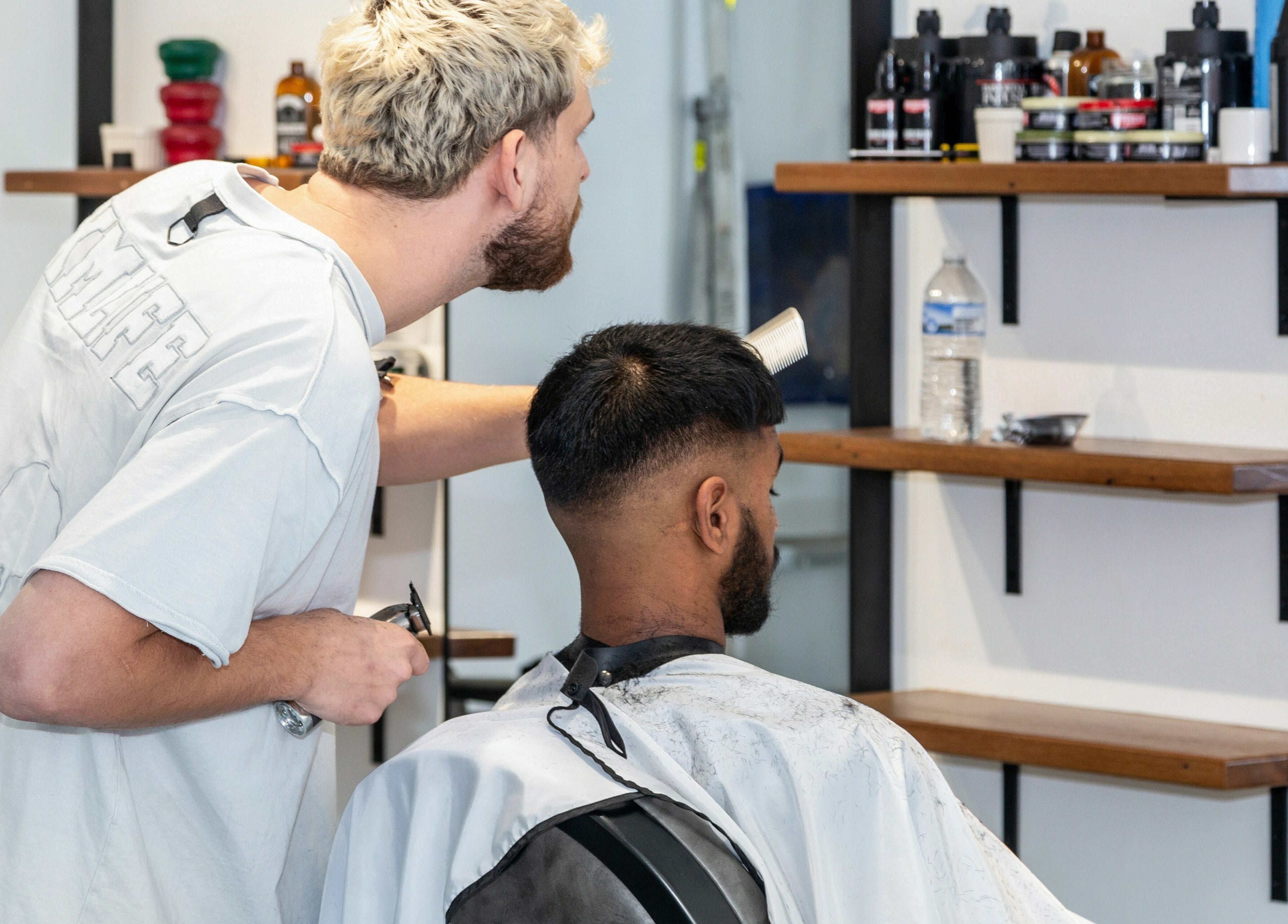 Barber styling man's hair at Boy Barbershop - Coolangatta in Coolangatta, QLD, AU. Modern and stylish atmosphere.