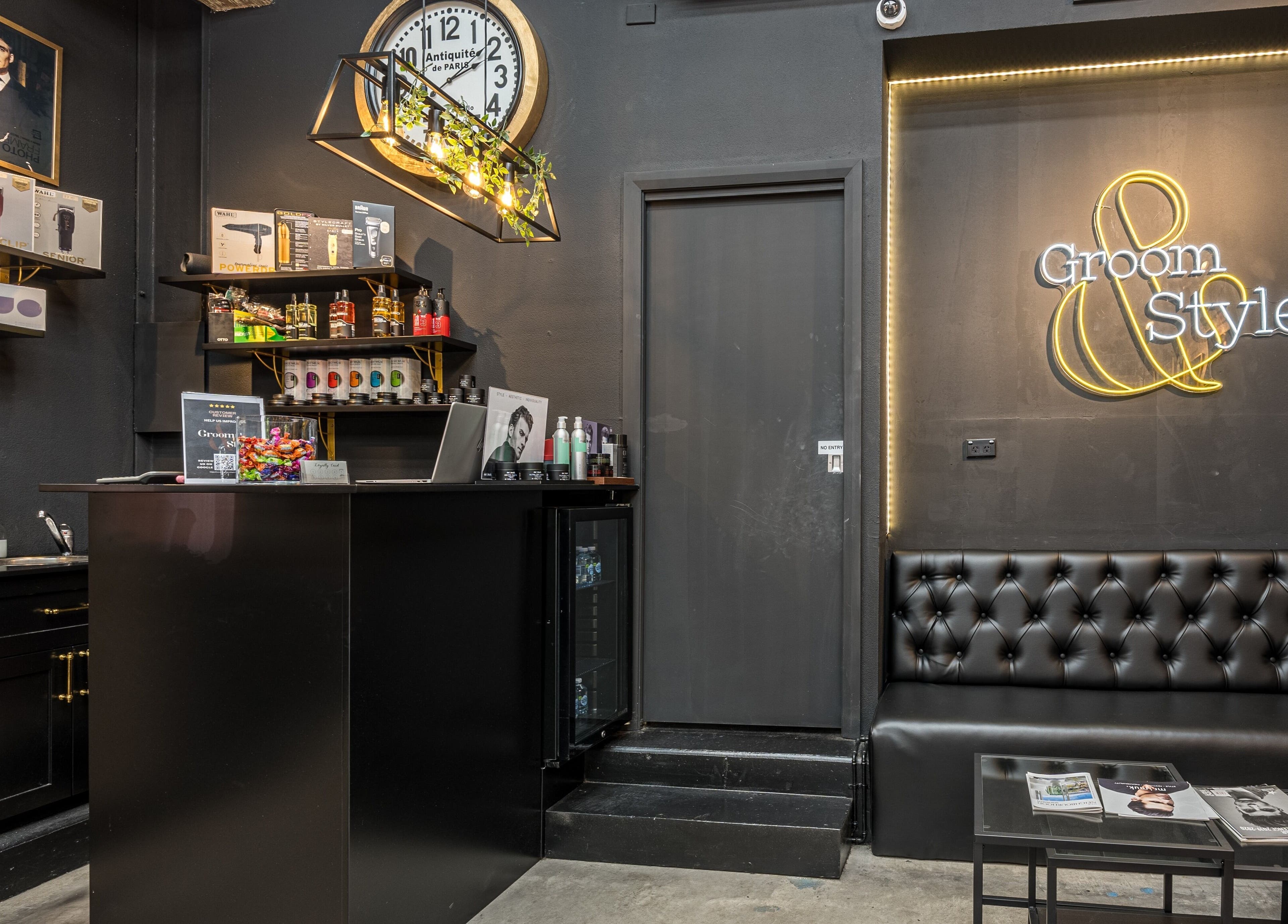Modern interior of Groom & Style Barber Shop in Waterloo, New South Wales, AU with sleek furnishings and neon sign.