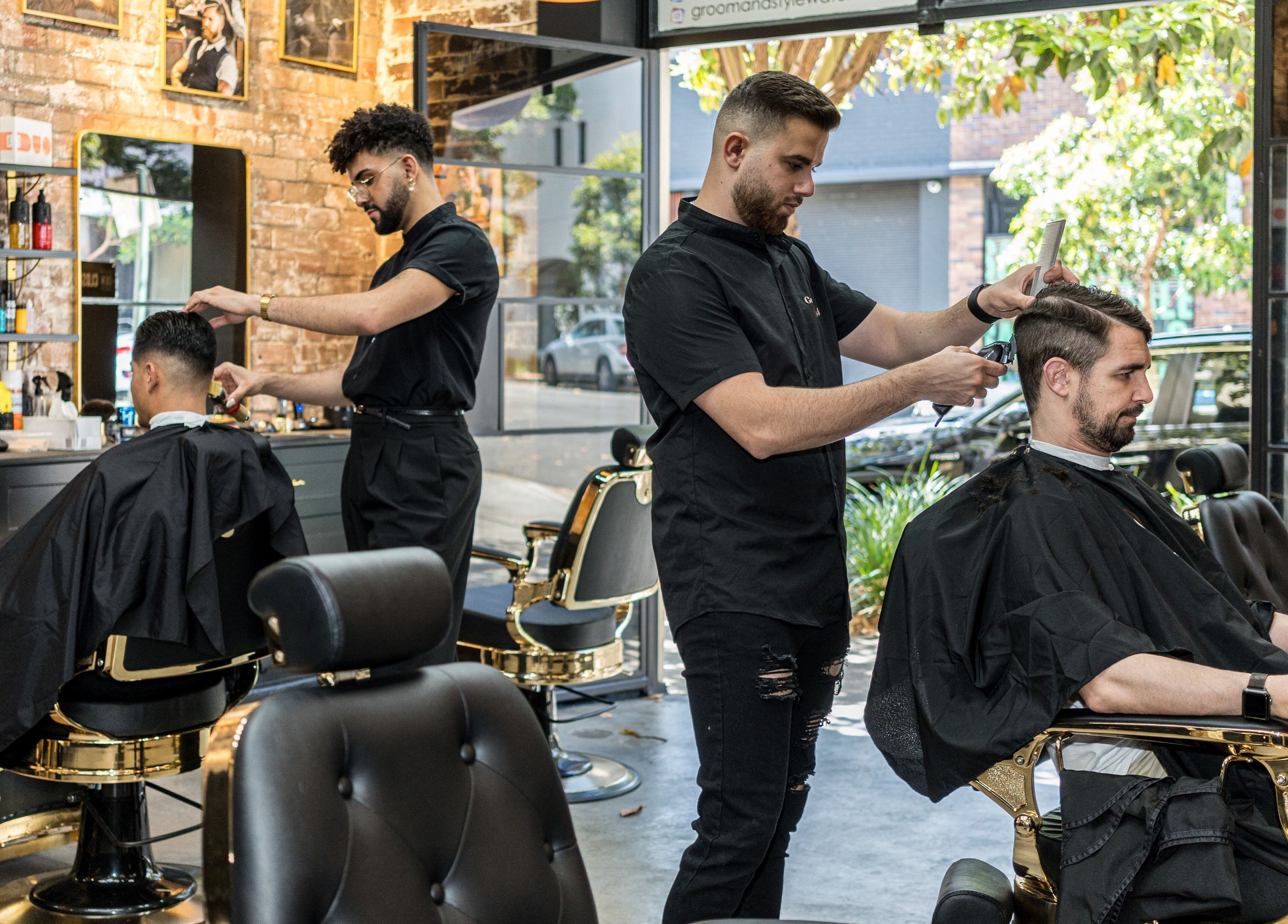 Barbers at work in Groom & Style Barber Shop, Waterloo, New South Wales, AU, creating trendy hairstyles.