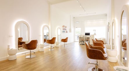 Bright, modern interior of Flourish Eco Hair, Mount Lawley, Western Australia, with stylish chairs and mirrors.