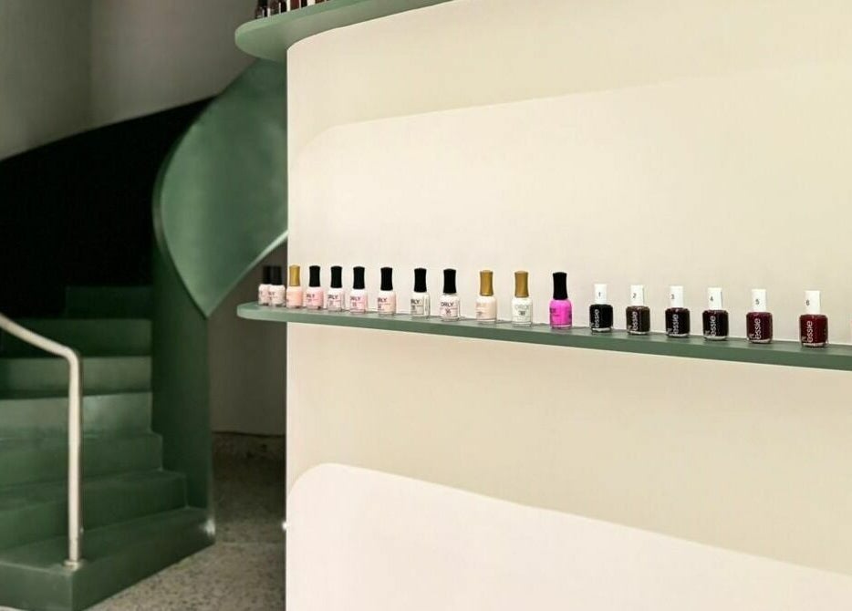 Nail polish lineup at Tend Salon | تند صالون, Riyadh, Riyadh Province, SA with a stylish spiral staircase.