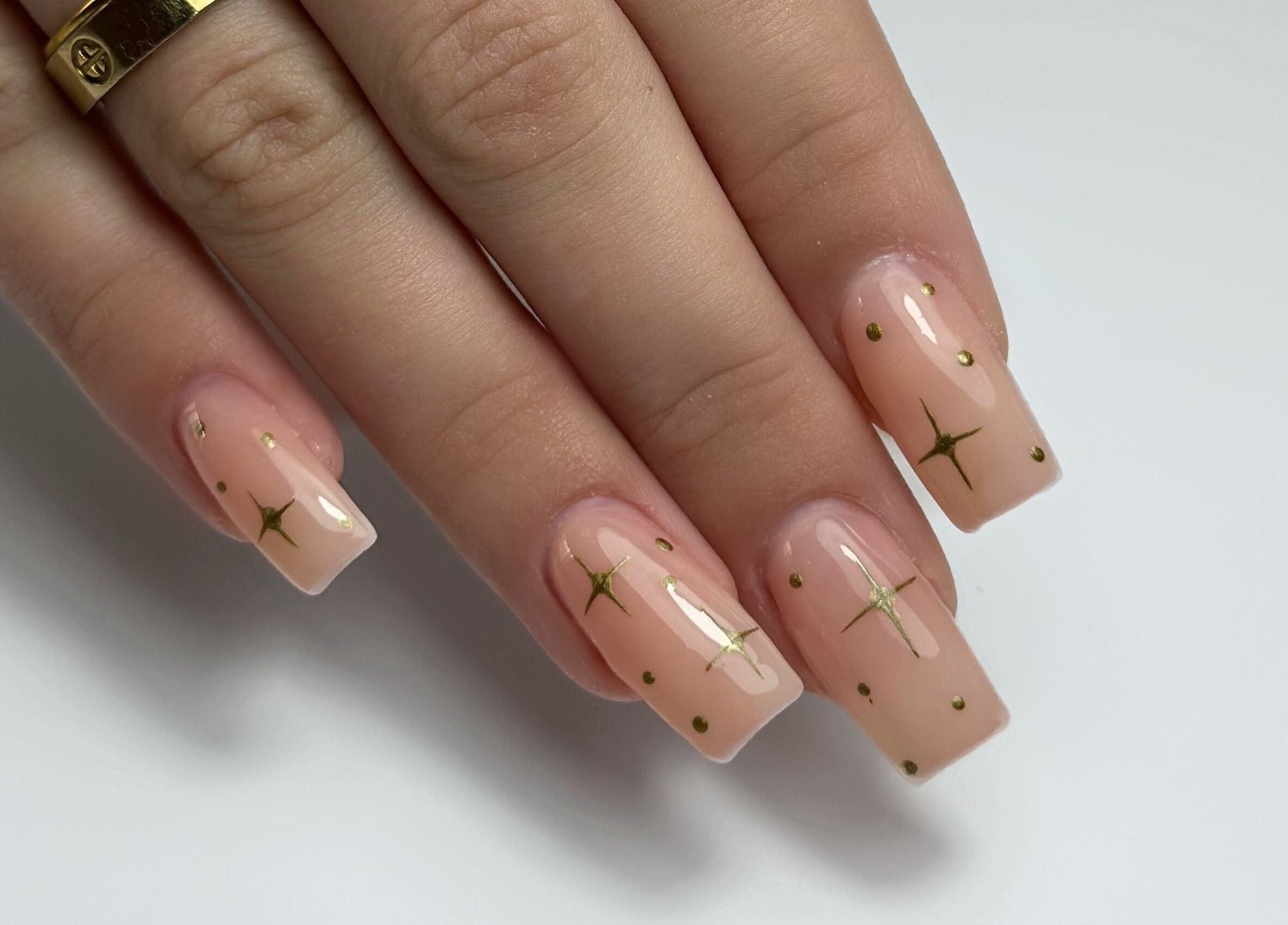 Elegant nail art with gold stars at Shaped & Polished, Mosta, MT. Perfect manicure showcasing glossy finish.