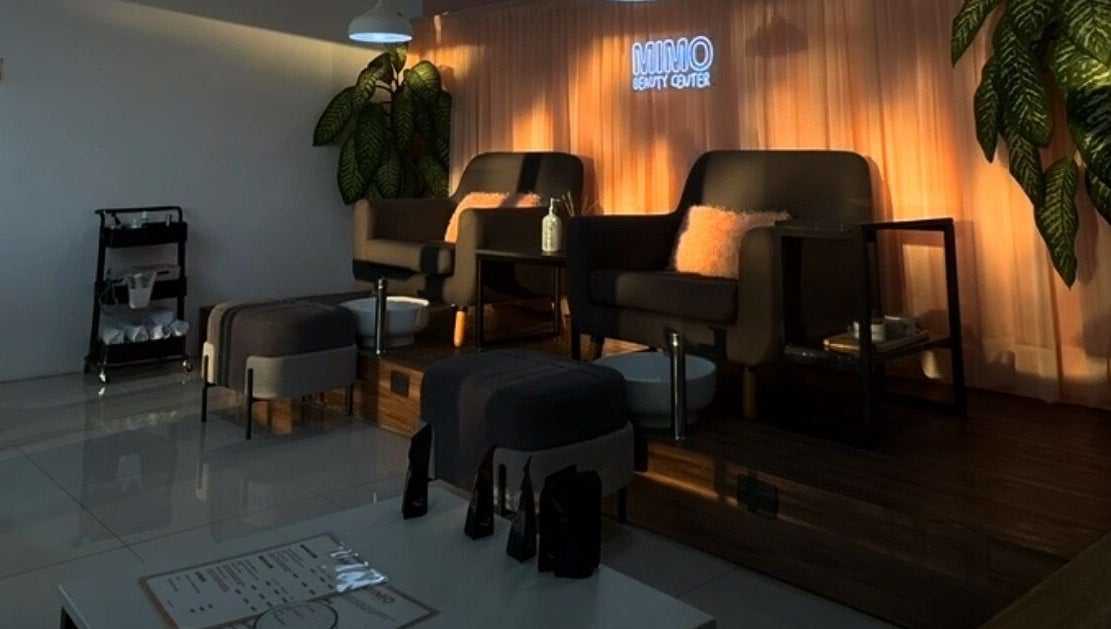Área de asientos cómodos en Mimo Beauty Center, Mérida, Yucatán, MX, con iluminación cálida y decoración moderna.