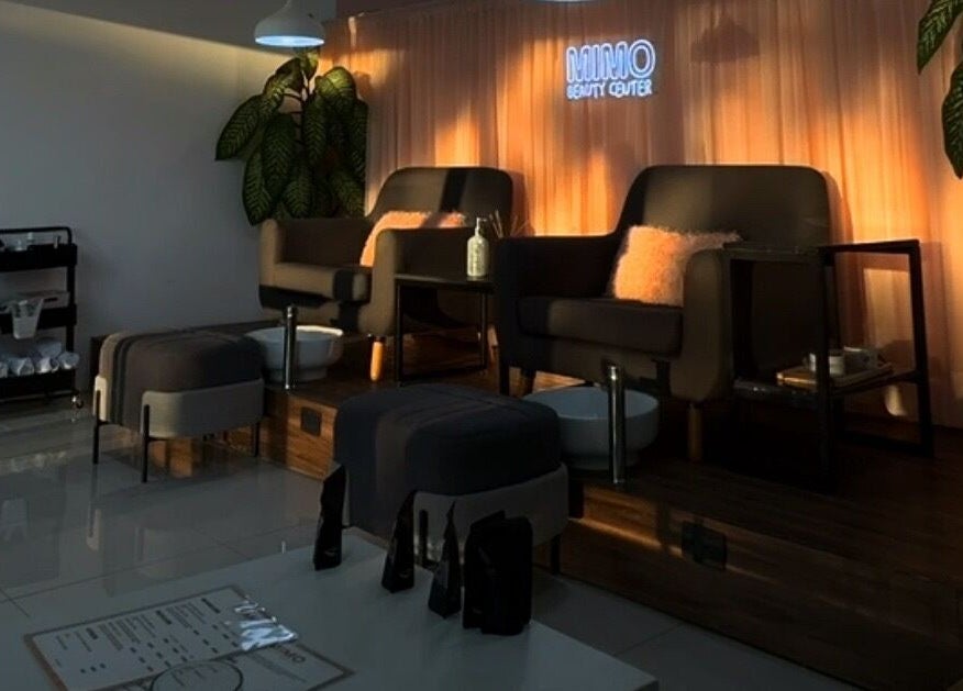 Área de asientos cómodos en Mimo Beauty Center, Mérida, Yucatán, MX, con iluminación cálida y decoración moderna.