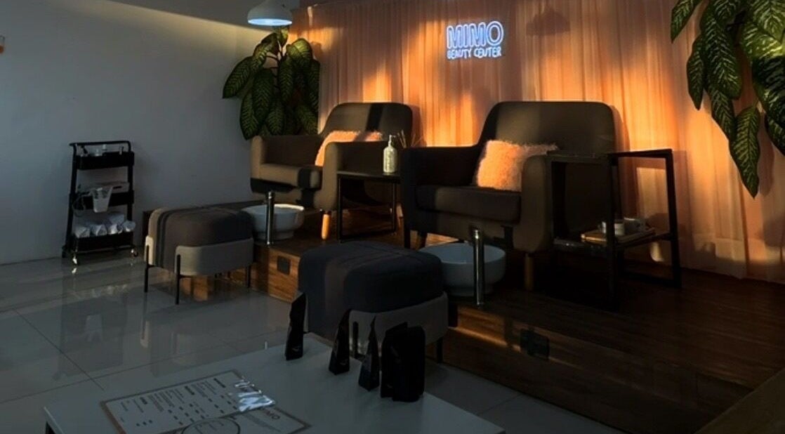 Área de asientos cómodos en Mimo Beauty Center, Mérida, Yucatán, MX, con iluminación cálida y decoración moderna.